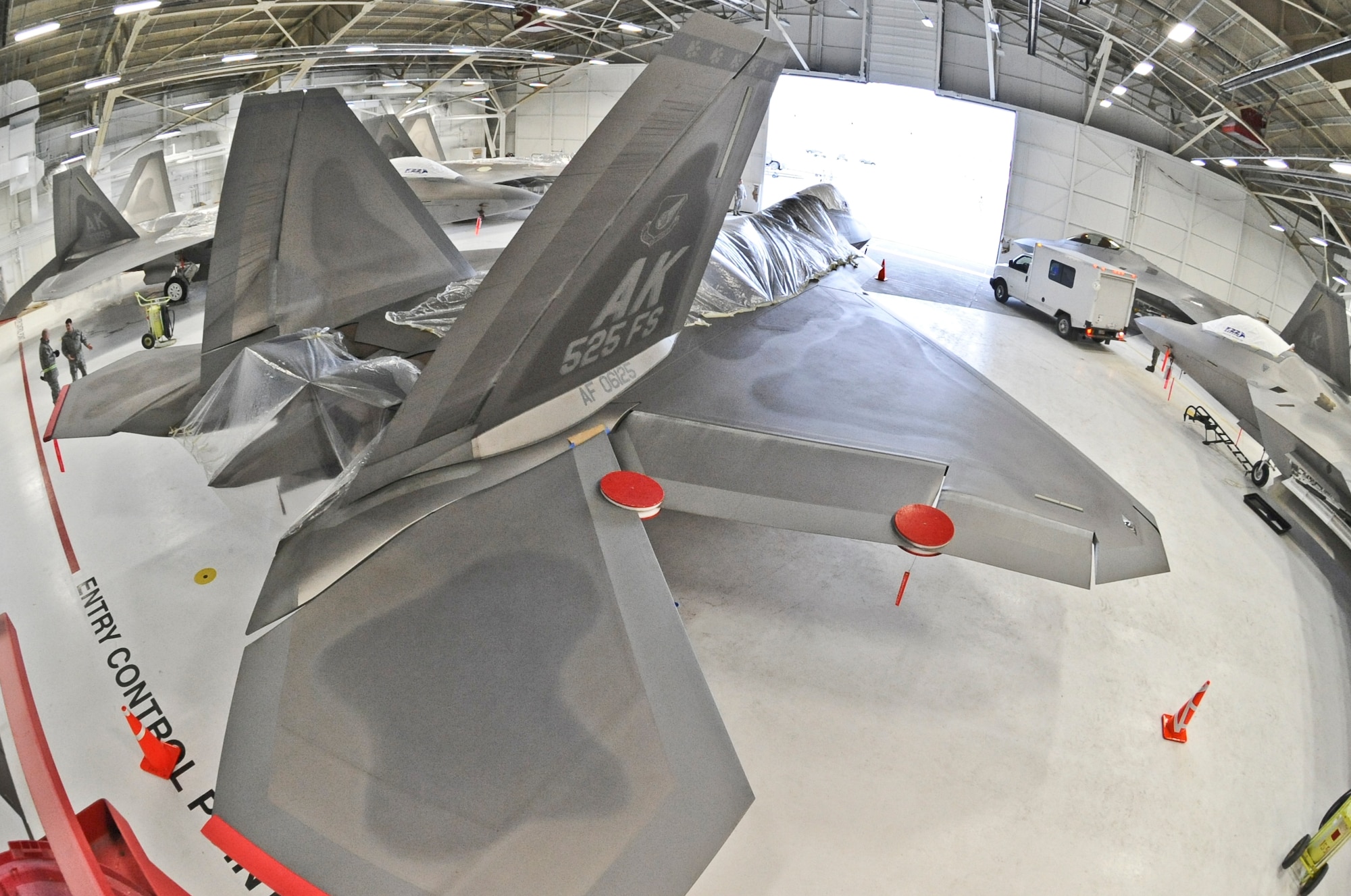 ELMENDORF AIR FORCE BASE, Alaska -- F-22 Raptors are being covered in plastic to provide additional protection from possible ash fall. The 525th Fighter Squadron aircraft are being sheltered inside a hangar due to the ongoing eruptions of Mount Redoubt. (U.S. Air Force photo by Senior Airman Matthew Owens)