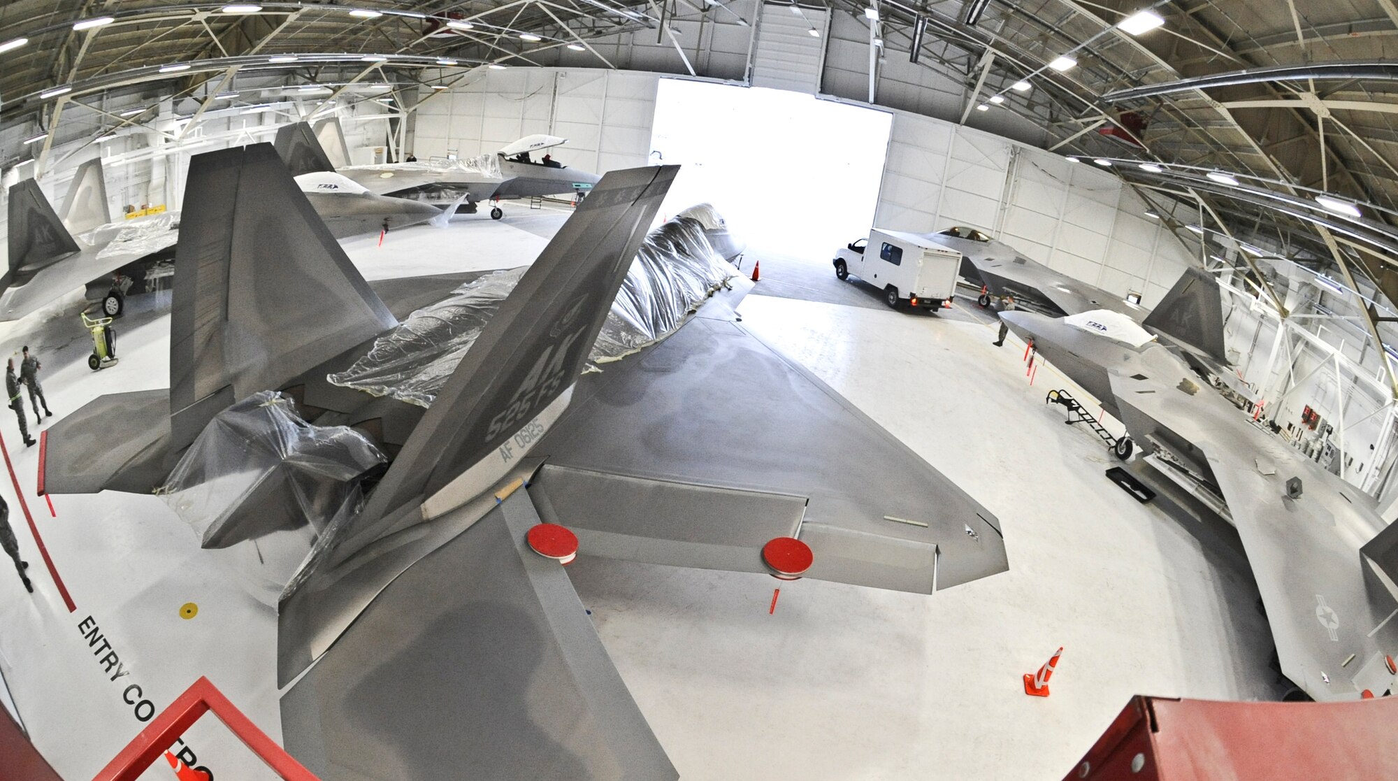 ELMENDORF AIR FORCE BASE, Alaska -- F-22 Raptors are being covered in plastic to provide additional protection from possible ash fall. The 525th Fighter Squadron aircraft are being sheltered inside a hangar due to the ongoing eruptions of Mount Redoubt. (U.S. Air Force photo by Senior Airman Matthew Owens)