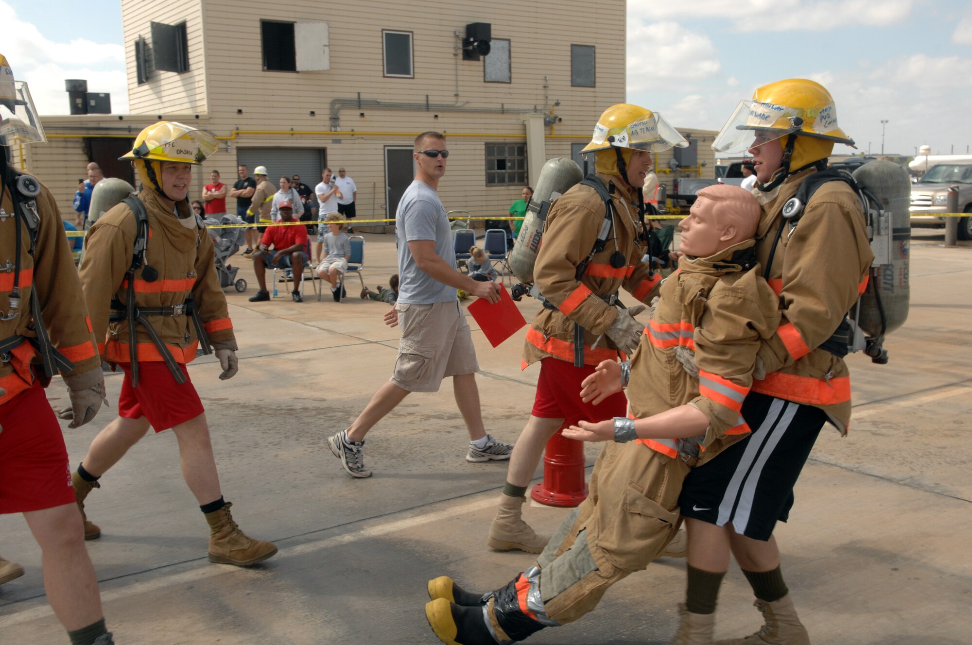 Members of the winning "Smokin’ Armadillos" team at the Rookie Firefighter Combat Challenge March 21 cheer on a teammate as he drags a 165-pound dummy 50 feet toward the finish line. The Smokin’ Armadillos are Marine Corps Pfcs. Joseph Gillespie, Jase Conners and Mikhail Okshin, and Airmen Basic Bryan Reid and Daryl Teage. The team won the event with an overall time of 1 minute, 32 seconds. (U.S. Air Force photo by Tech. Sgt. John Barton)