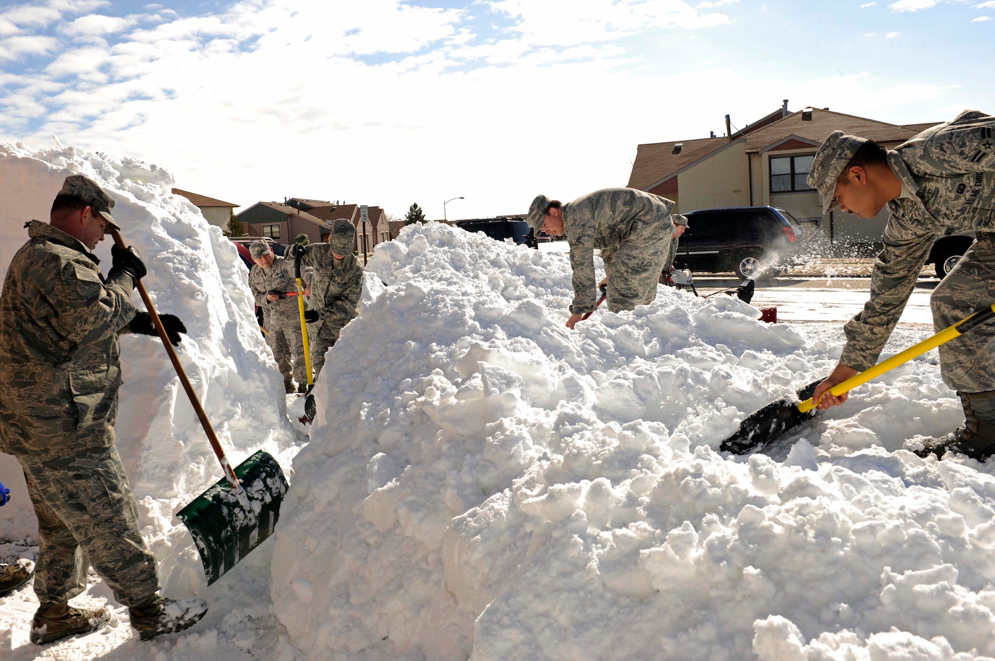 Airmen from the Air Force Financial Services Center shovel snow here, March 25. They cleared snow in base housing for a deployed co-workers spouse. Up to 15 inches of snow accumulated on base from the March 23 blizzard, which closed the base for one day and caused snow drifts in excess of 6 feet. (U.S. Air Force photo by Airman First Class Corey Hook)