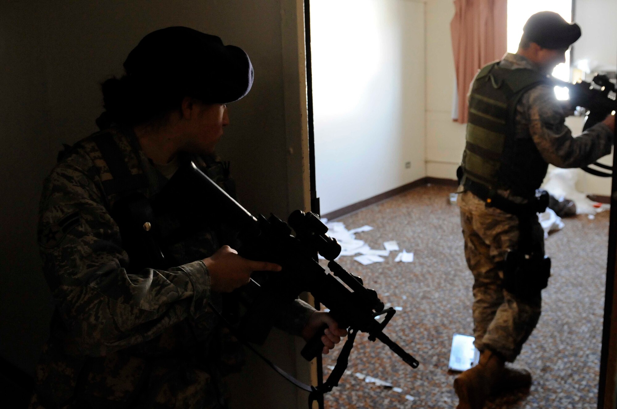 (Left to Right) Airmen 1st Class Elizabeth Bolanos and Steven Fischer, 28th Security Forces Squadron, perform a dynamic entry for training purposes at here, March 25. Dynamic entries are used for high-risk incidents that could require the use of armed force to quell the situation. (U.S. Air Force photo by Airman First Class Corey Hook)