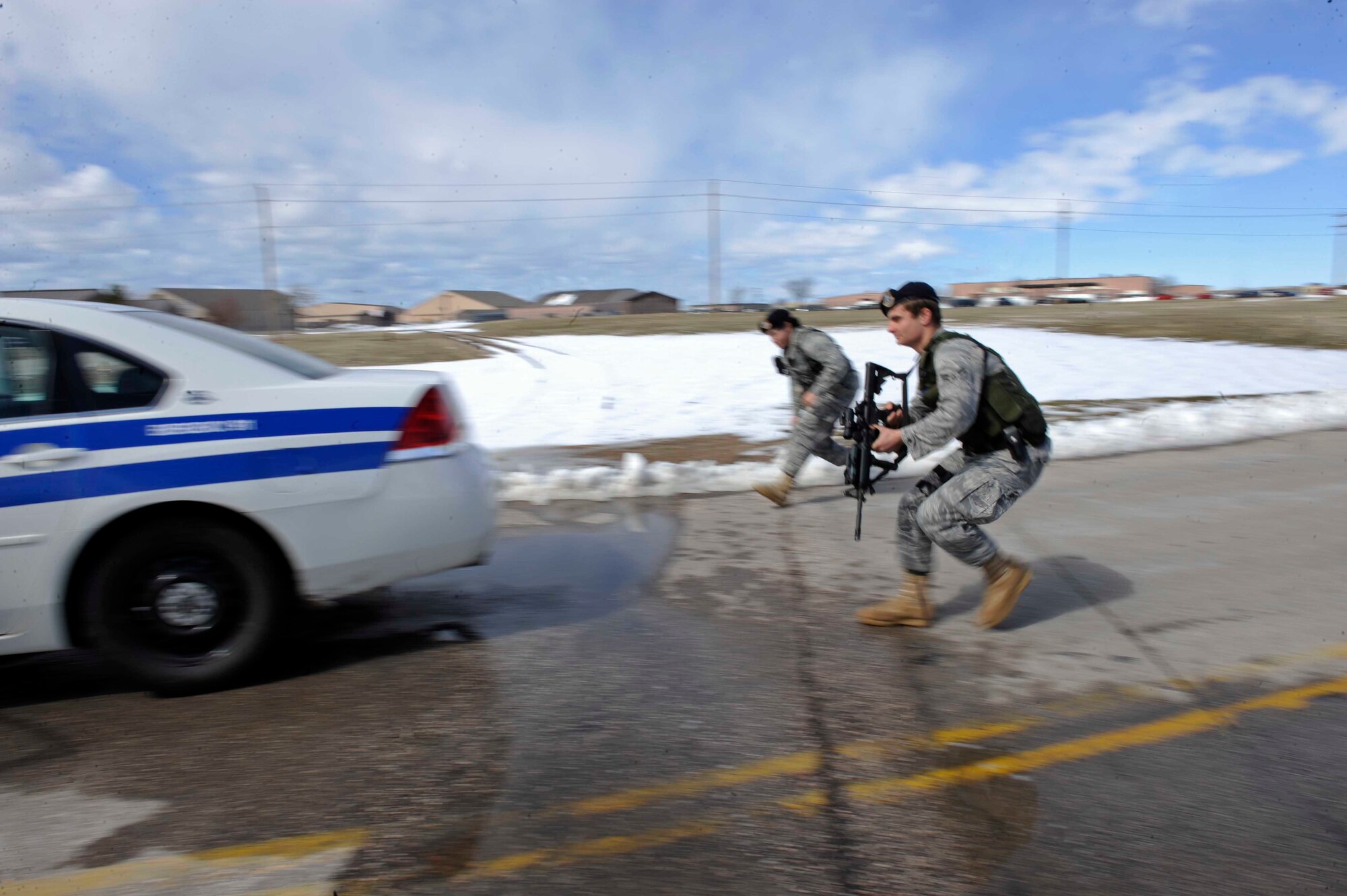 (Front to Back) Airmen 1st Class Steven Fischer and Elizabeth Bolanos, 28th Security Forces Squadron, approach a security forces vehicle during a high-risk traffic stop training scenario here, March 25. Security forces personnel are the Air Force's first line of defense and it is their job to uphold the law on all Air Force bases and installations. (U.S. Air Force photo by Airman First Class Corey Hook)