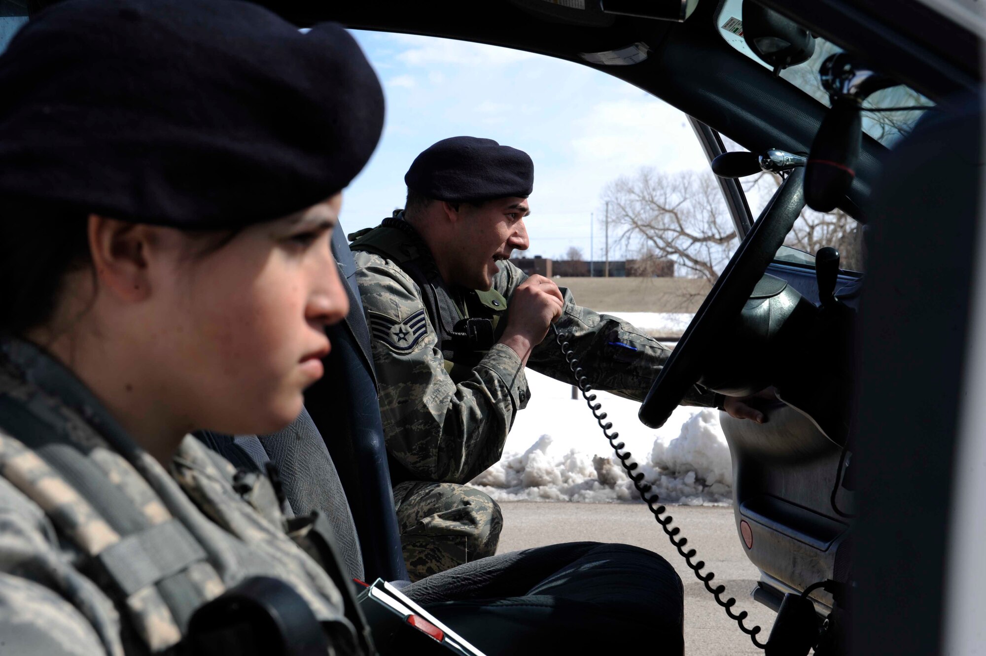 (Left to Right) Airman 1st Class Elizabeth Bolanos, 28th Security Forces Squadron, and Staff Sgt. Marc Muzio, 28 SFS leader, uses a microphone to challenge Senior Airman Amanda Clark, 28 SFS leader, during a high-risk traffic stop training scenario here, March 25. Security forces personnel are the Air Force's first line of defense and it is their job to uphold the law on all Air Force bases and installations. (U.S. Air Force photo by Airman First Class Corey Hook)