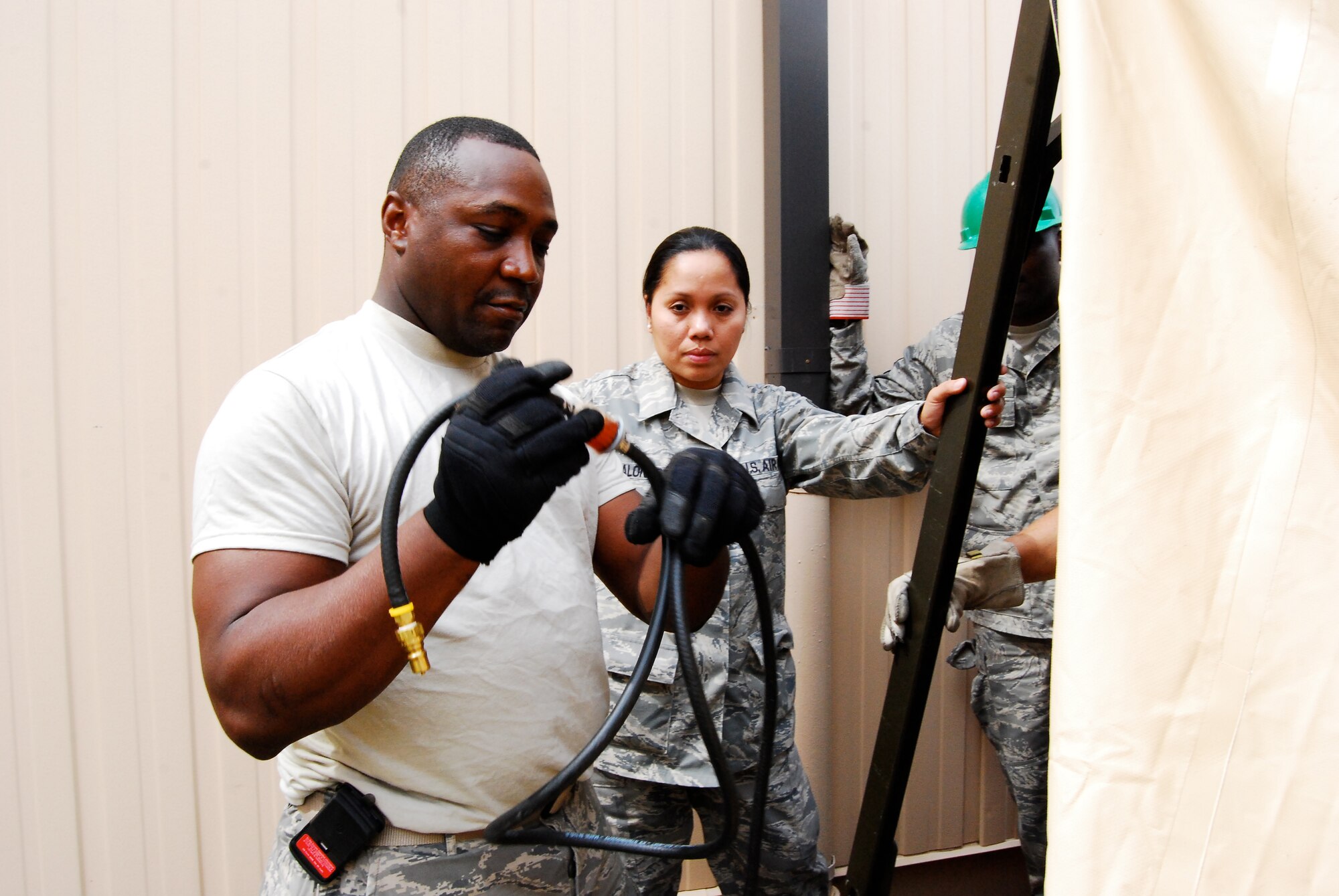 DOBBINS AIR RESERVE BASE, Ga. - Tech Sgt. John Joyner, left, combat services training instructor, 94th Airlift Wing, shows Master Sgt. Juliet Alonzo, 622nd Regional Support Group, how to set up gas lines for a single pallet expeditionary kitchen. Sergeant Alonzo received field training on preparing and providing meals during the 22nd Air Force Aerial Port ROUNDUP, March 13-15, here. (U.S. Air Force photo/Staff Sgt. Steve Lewis)