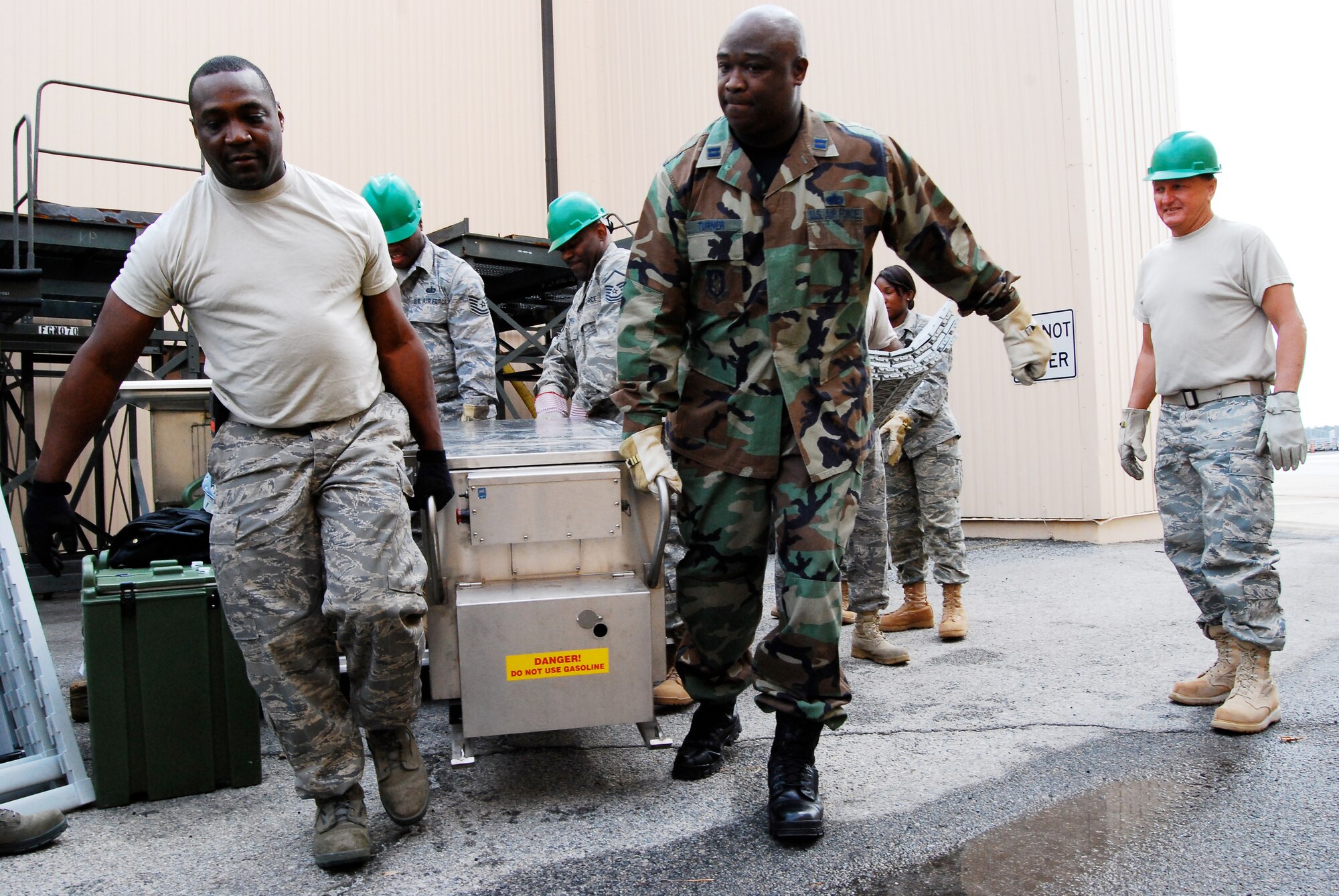 DOBBINS AIR RESERVE BASE, Ga. - Tech Sgt. John Joyner, left, combat services training instructor, 94th Airlift Wing, helps Capt. Eric Turner, 22nd Air Force, bring food preparation equipment into the single pallet expeditionary kitchen tent. Captain Turner helped the services team prepare and serve meals during the 22nd Air Force Aerial Port ROUNDUP, March 13-15, here. (U.S. Air Force photo/Staff Sgt. Steve Lewis)