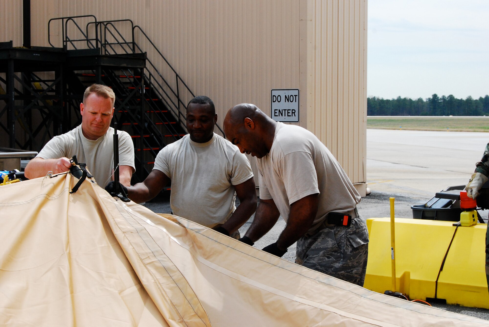 DOBBINS AIR RESERVE BASE, Ga. - From left to right, Lt. Col. John Hayes, 22nd Air Force services director, receives training on how to set up a single pallet expeditionary kitchen from combat services training instructors Tech Sgts. John Joyner and Jovor Dungee. The instructors conducted field training to Reserve Services units on preparing and providing meals during the 22nd Air Force Aerial Port ROUNDUP, March 13-15, here. (U.S. Air Force photo/Staff Sgt. Steve Lewis)