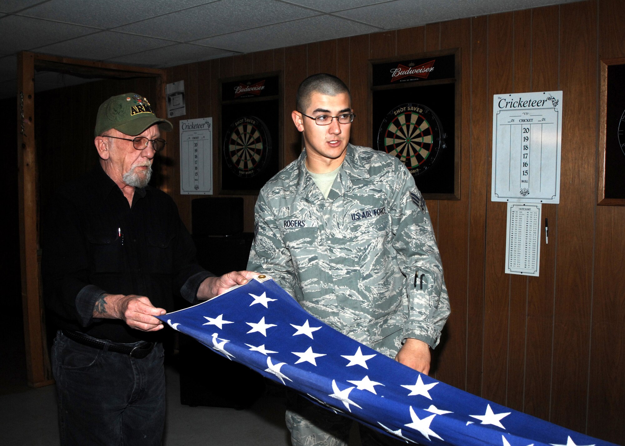 CANNON AIR FORCE BASE, N.M. -- Senior Airman Nathan Rogers, 27th Special Operatons Wing Honor Guard,  watches as Edward Noll, a member of American Veterans, Post 14 in Clovis, N.M. practices the proper techniques in flag folding for military funeral honors March 21. AMVETS members will, after certification, assist the base honor guard during funeral services for veterans. (U.S. Air Force photo/Greg Allen)  