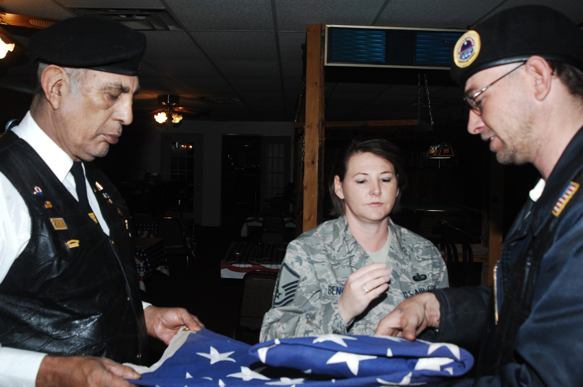 CANNON AIR FORCE BASE, N.M. -- Master Sgt. Amy Bengry, 27th Special Operations Wing Honor Guard superintendent, instructs Rev. Manuel Medina and William Beckwith, members of American Post 14 in Clovis, N.M., March 21. on the proper procedures for folding a flag during a military funeral ceremony. The post voluneered to train with the honor guard to provide additional support for military funerals for veterans. (Air Force photo by Greg Allen)