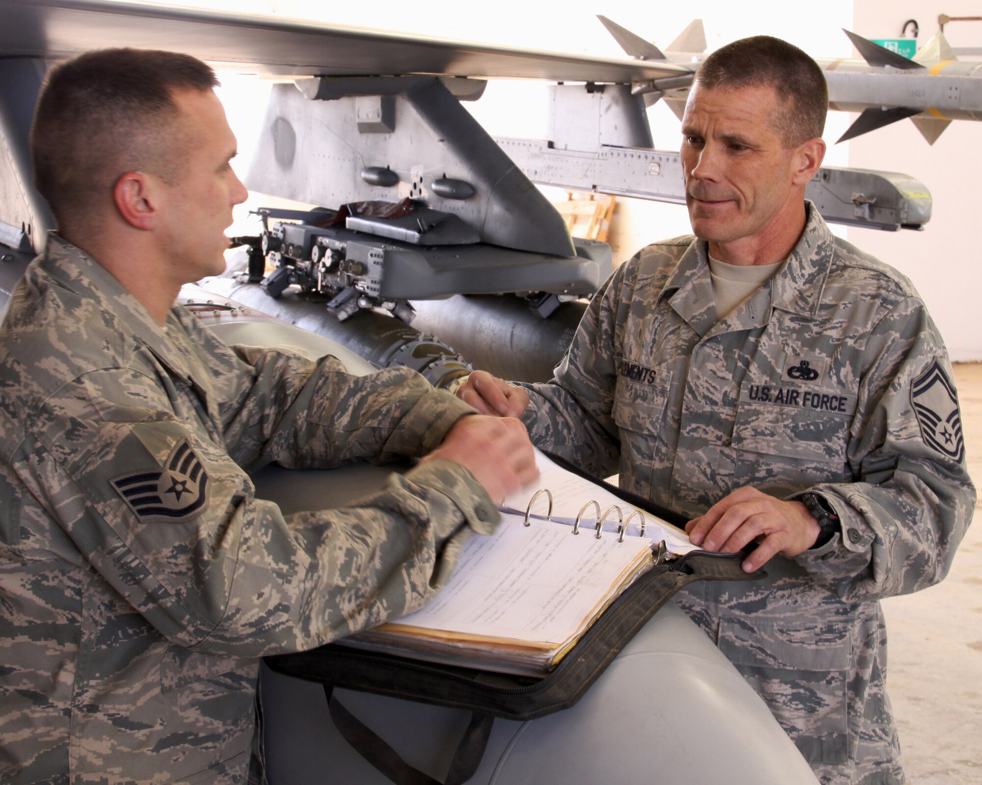 Senior Master Sgt. Scott Clements, right, 4th Aircraft Maintenance Unit productions supervisor, reviews forms with Staff Sgt. Brandon Howe, 332nd Expeditionary Aircraft Maintenance Squadron at Joint Base Balad, Iraq, March 2, 2009. Both are deployed to Balad from Hill Air Force Base, Utah. (U.S. Air Force photo/Tech. Sgt. Lionel Castellano)