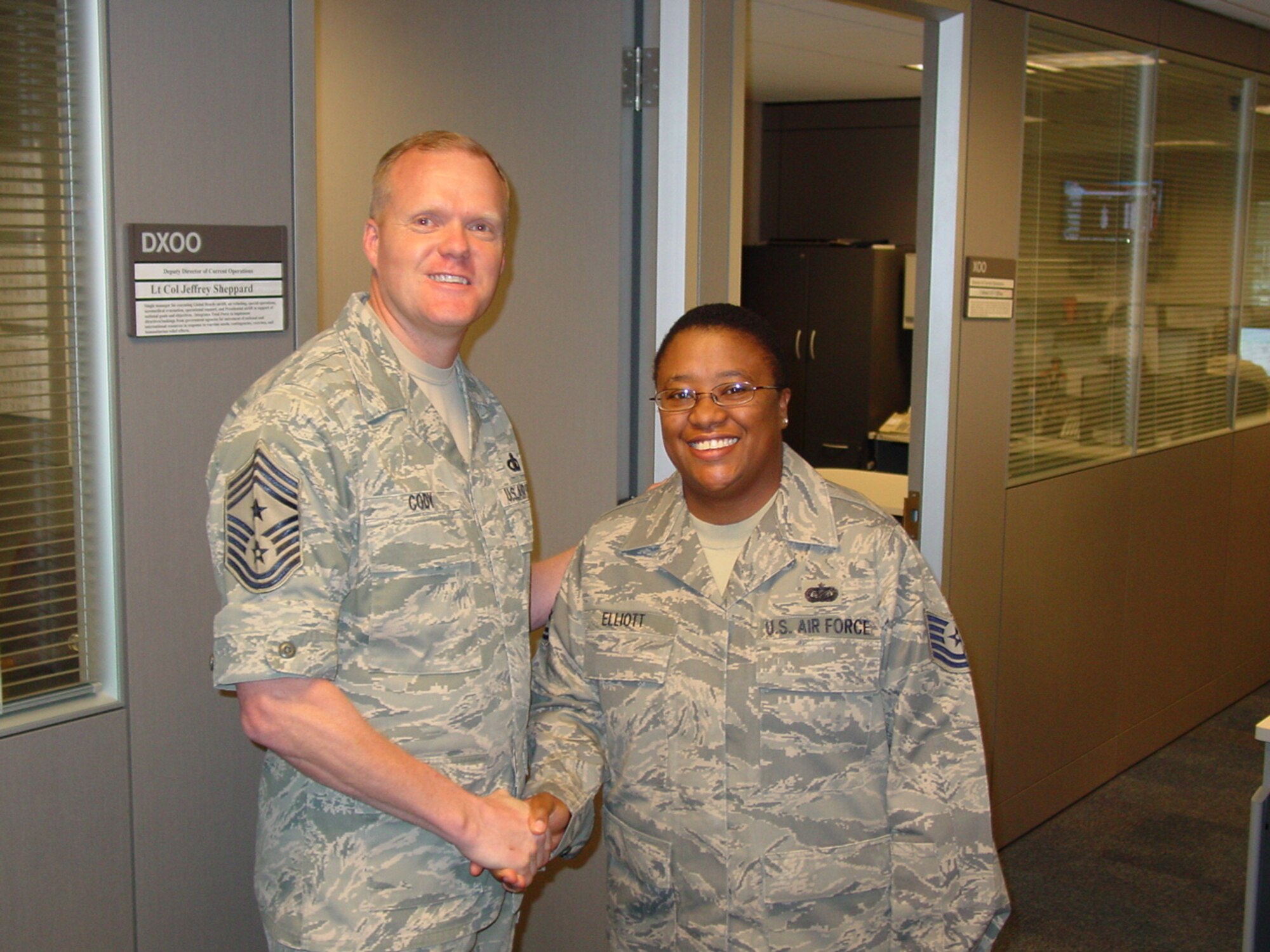 Chief Master Sgt. James Cody, 18th Air Force Command Chief Master Sergeant, presents his coin to Tech. Sgt. Tonia Elliott, from the 618th Tanker Airlift Control Center's Current Operations Directorate.  Chief Cody visited the 618th TACC to meet with Airmen and recognize a number of personnel who have been instrumental in training and mentoring fellow Airmen. 