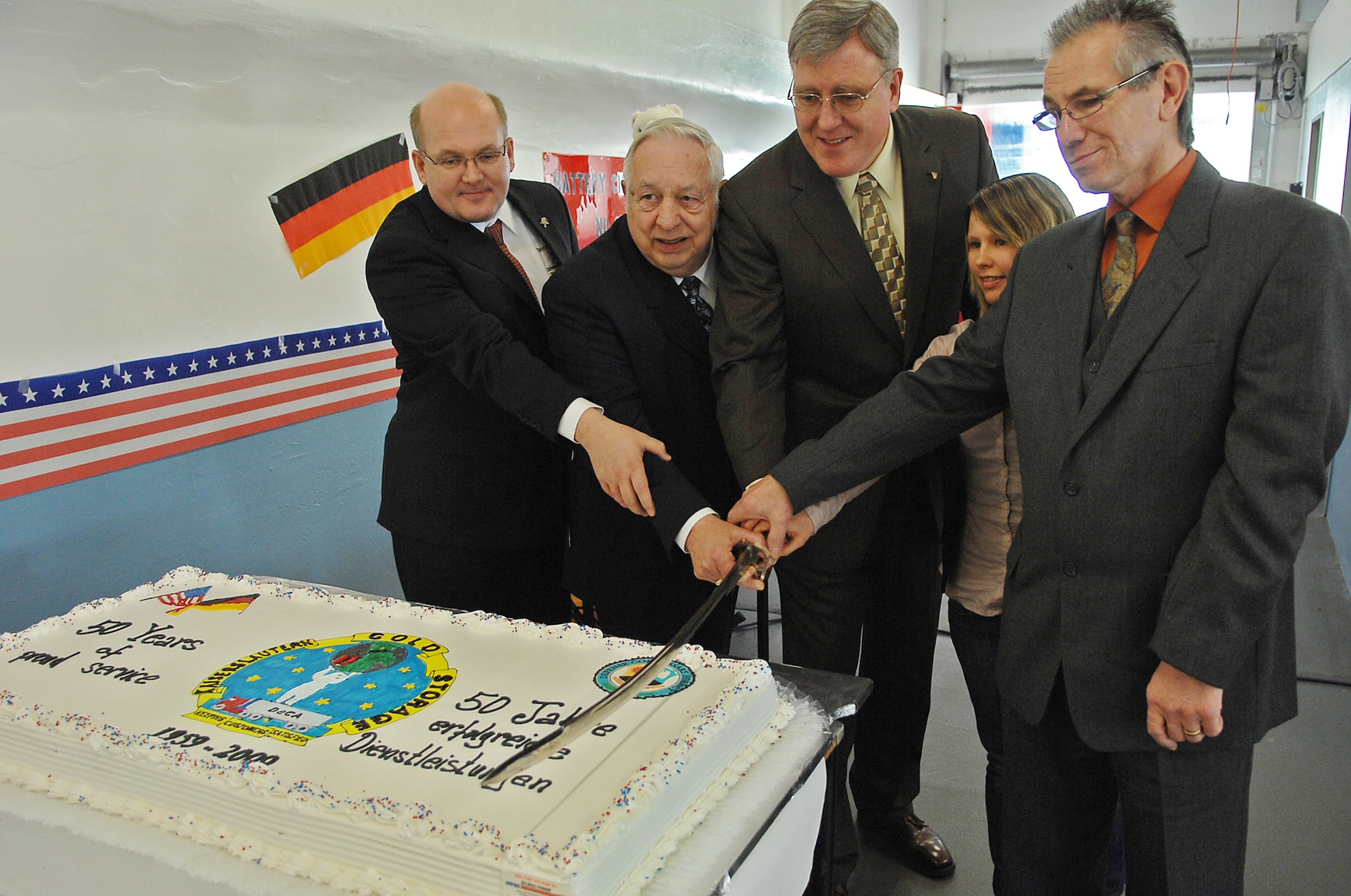 Terry Batenhorst, DeCA Europe director of operations, Austin Romesburg, Kaiserslautern Cold Storage(KCS) chief, Thomas E. Milks, DeCA Europe director, and KCS newest and longest employed members (left to right) cut the cake during a ceremony celebrating KCS's 50th anniversary, Ramstein Air Base, Germany, March 20, 2009. (U.S. Air Force photo by Airman 1st Class Tony R. Ritter)