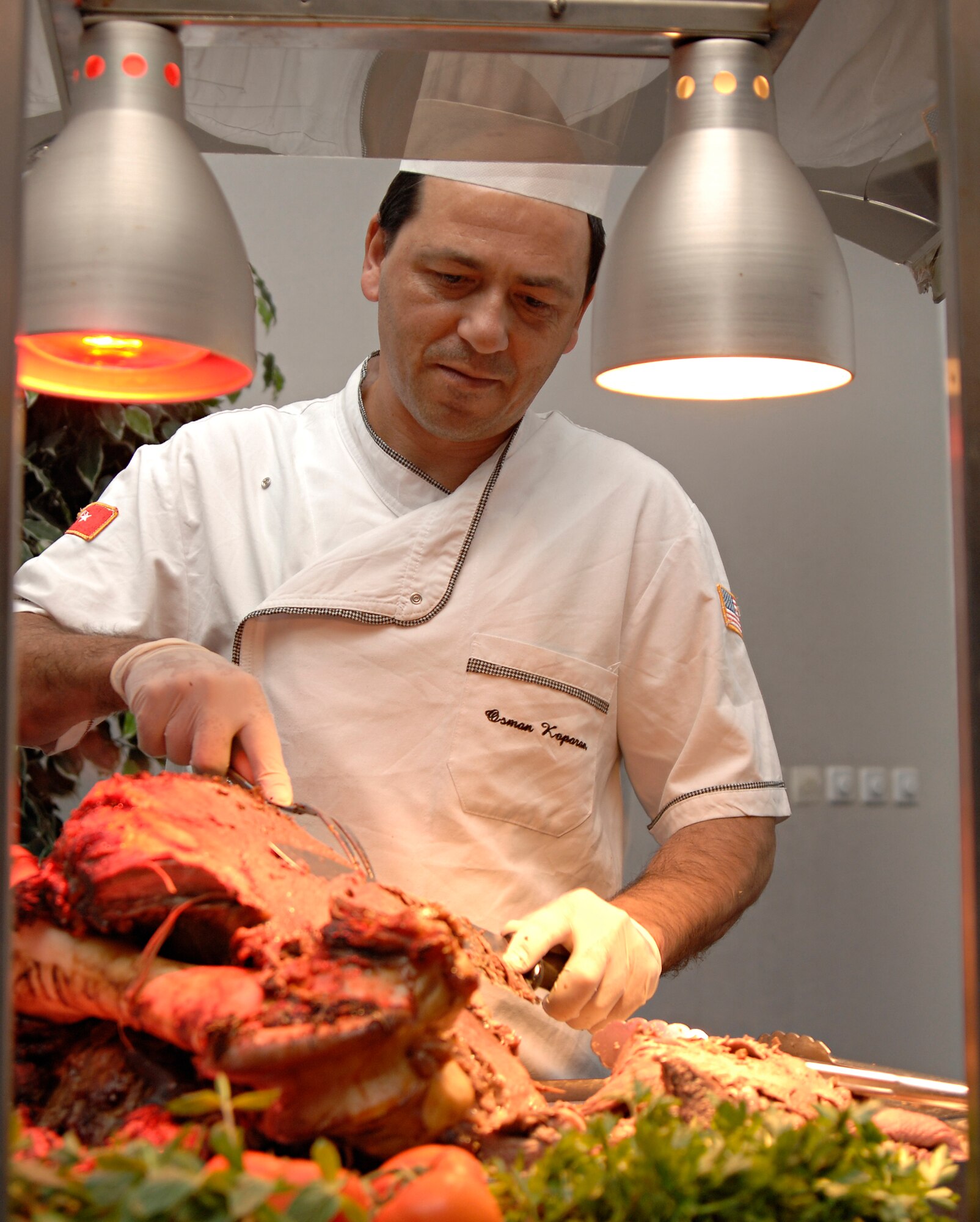 Osman Kaparan, Incirlik Consolidated Club staff member, carves slices of roast beef during a club member appreciation night, Wednesday, March 25, 2009. The event was hosted by the club to express gratitude to its members and Chef Jean Marc Laurent, United States Air Forces in Europe command chef, prepared the food, which was free to all club members. (U.S. Air Force photo/Senior Airman Benjamin Wilson, 39th Air Base Wing Public Affairs)