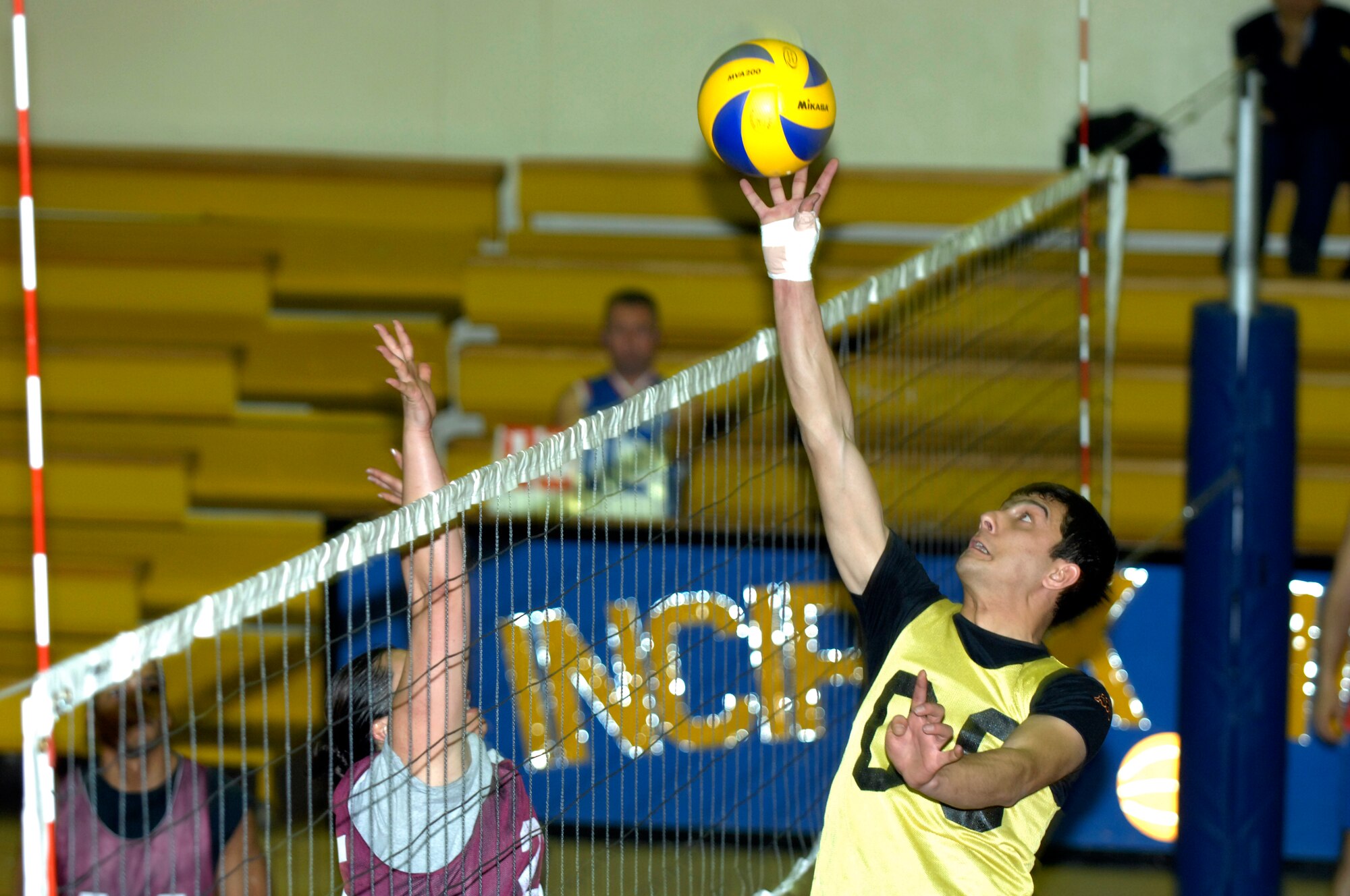 Sukru, Maintenance 2, tips the ball over the net and just past the reach of Bernadette Ignacio, Team 2, during a volleyball game, Tuesday, March 24, 2009 at the Incirlik Fitness Center. Maintenance 2, made up of personnel from the Turkish air force, beat Team 2, made up of personnel from the U. S. Air Force, with a score of 25-8. The U.S. and Turkish Air Forces have volleyball matches scheduled for 12:00 p.m. in the Incirlik Fitness Center all week increase the good relations between the U.S. Air Force and their host nation counterparts. (U.S. Air Force photo by Senior Airman Benjamin Wilson, 39th Air Base Wing Public Affairs)
