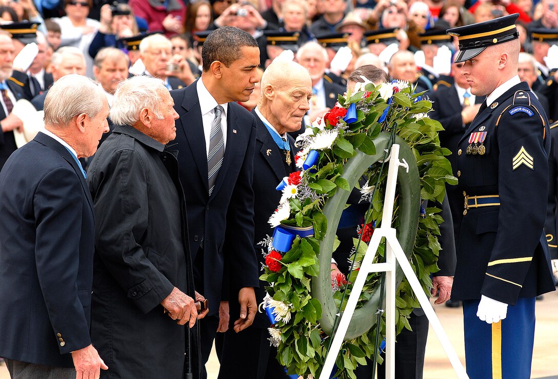 President Barack Obama, accompanied by Medal of Honor recipients, lays a wreath at the Tomb of the Unknowns at Arlington National Cemetery during National Medal of Honor Day at Arlington National Cemetery, March 25, 2009. in a statement, Obama described Medal of Honor recipients as "foremost examples of greatness in service and sacrifice."