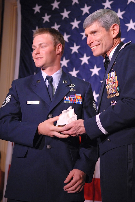 U.S. Air Force Gen. Norton A. Schwartz, Air Force chief of staff, presents U.S. Air Force Staff Sgt. Zachary Rhyner, left, with a United Service Organizations of Metropolitan Washington Special Salute award during the USO-Metro 27th Annual awards dinner at the Ritz Carlton Hotel, Arlington, Va., March 25, 2009.