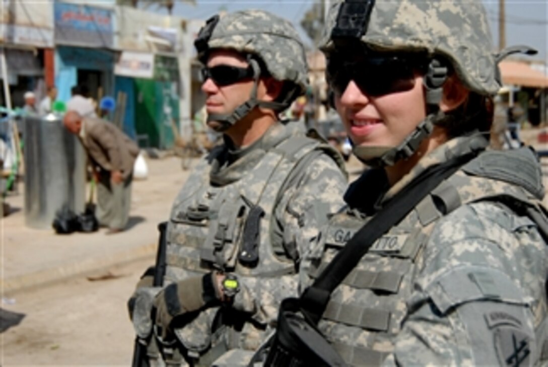 U.S. Army Spc. Laura Garretto (right) of Bravo Company, 403rd Civil Affairs Battalion, 172nd Infantry Brigade, gives Col. Daniel Ammerman of 304th Civil Affairs Brigade a tour through a market in Mahawil, Iraq, on March 18, 2009.  