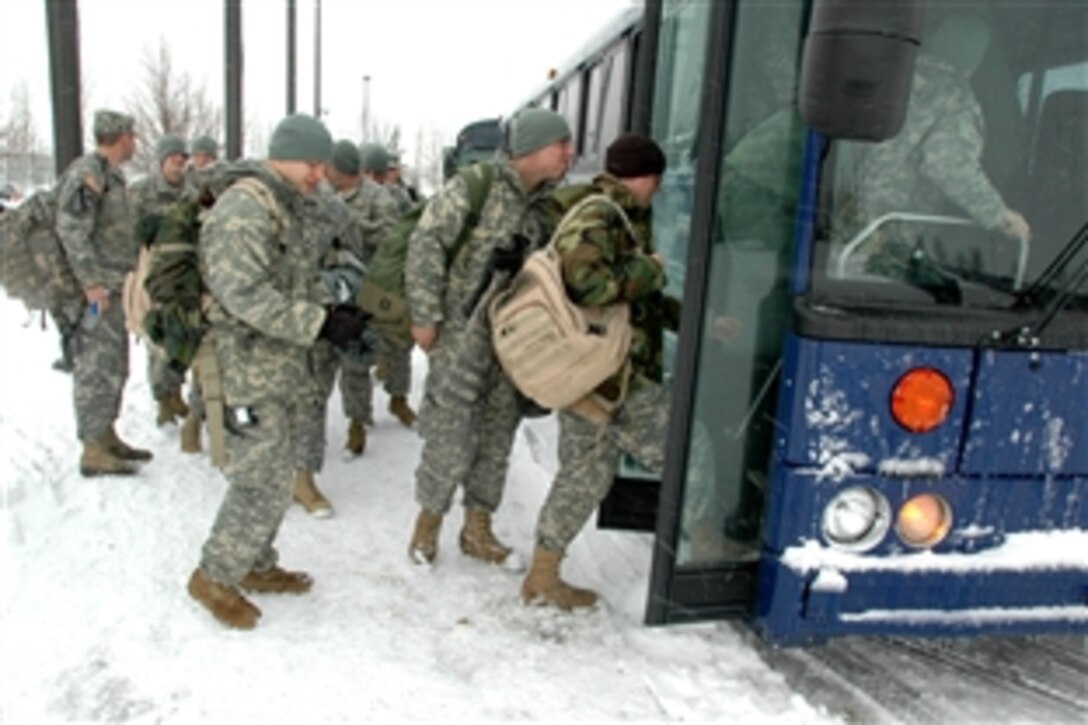 Soldiers and airmen of the North Dakota National Guard board a bus to the Red River where they will help sandbag dikes, March 25, 2009 in Fargo, N.D. 