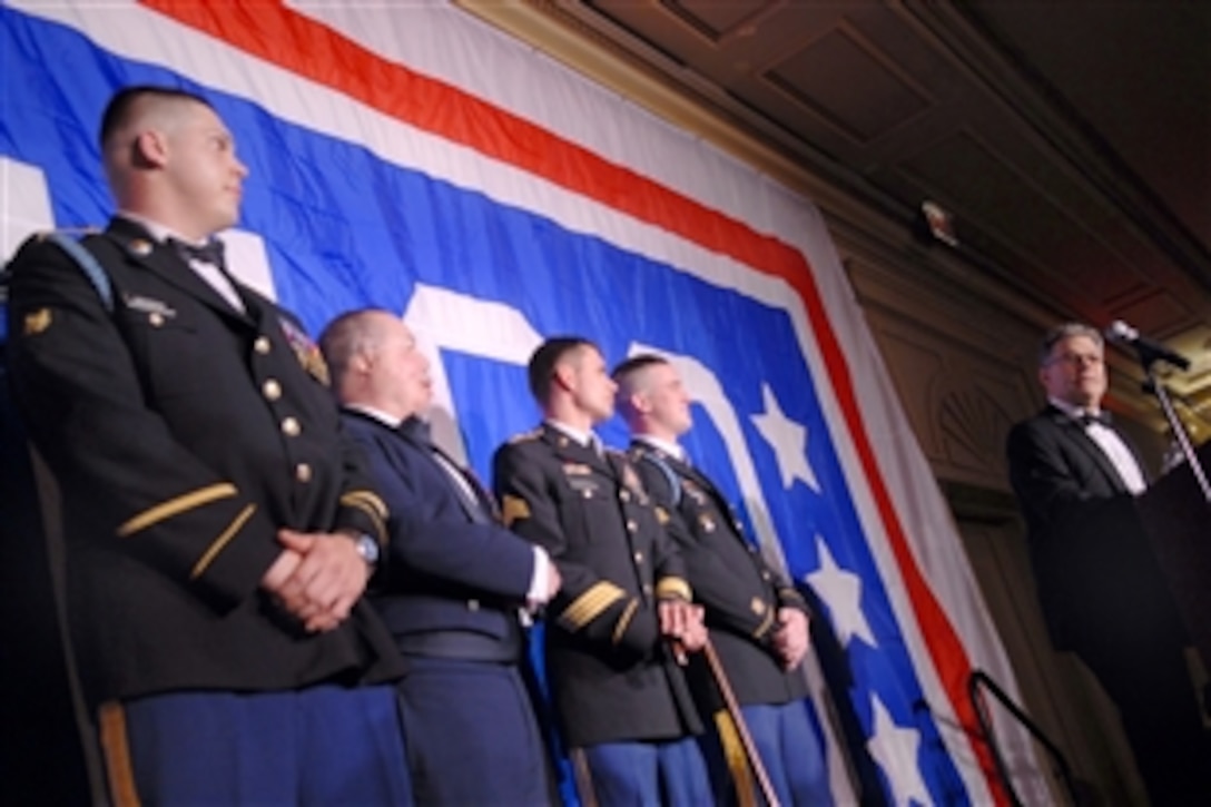 Comedian-politician Al Franken, far right, talks about his commitment to the United Service Organization and military members after being presented the USO-Metro Merit Award by the wounded warriors on stage with him during the USO-Metro 27th Annual Awards dinner in Arlington, Va., March 25, 2009.