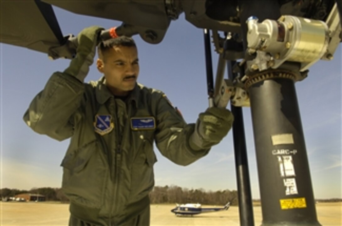 U.S. Air Force Staff Sgt. Pedro Melendez, a flight engineer with the 1st Helicopter Squadron, performs preflight checks on a UH-1 Huey helicopter at Andrews Air Force Base, Md., on March 24, 2009.  