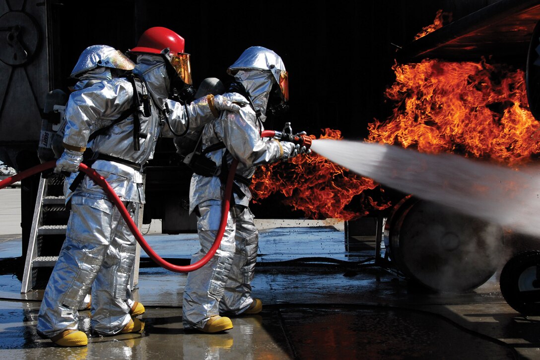 Lt. Col. Matt Puglisi, Marine Wing Support Squadron 372 commanding officer, and Gunnery Sgt. Jay Gibson, MWSS-372 Aircraft Rescue Fire Fighting crash chief, extinguish a simulated aircraft fire on Marine Corps Air Station Yuma's flight line March 26. The Camp Pendleton, Calif., based squadron is participating in the current Weapons and Tactics Instructor course, which began March 9 and is scheduled to end April 26.