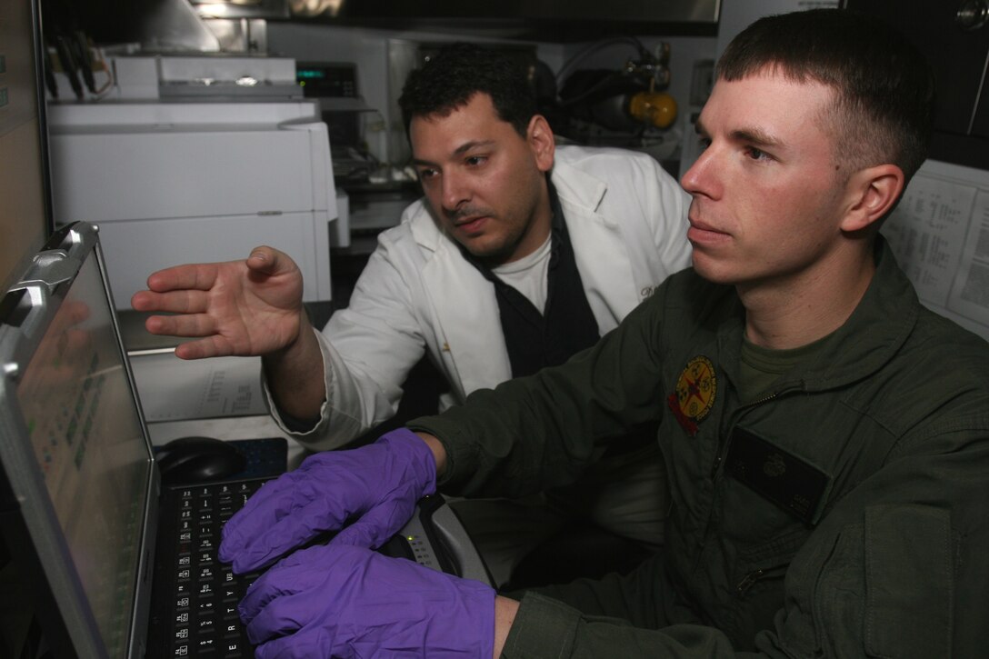 Erick Swartz, who is the resident scientist here and has a doctorate in chemistry trains Lance Cpl. Logan Carr, mobile laboratory operator, identification and detection platoon, Headquarters and Service Company, Chemical Biological Incident Response Force, II Marine Expeditionary Force on how to analyze a sample. Swartz helped to design the new mobile lab.