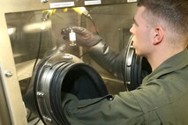 Lance Cpl. Logan Carr, mobile laboratory operator, identification and detection platoon, Headquarters and Service Company, Chemical Biological Incident Response Force, II Marine Expeditionary Force, analyzes a sample he tested in the glove box here March 26. After IDP Marines skillfully extract samples from the contaminated area, samples are then analyzed in the mobile lab.