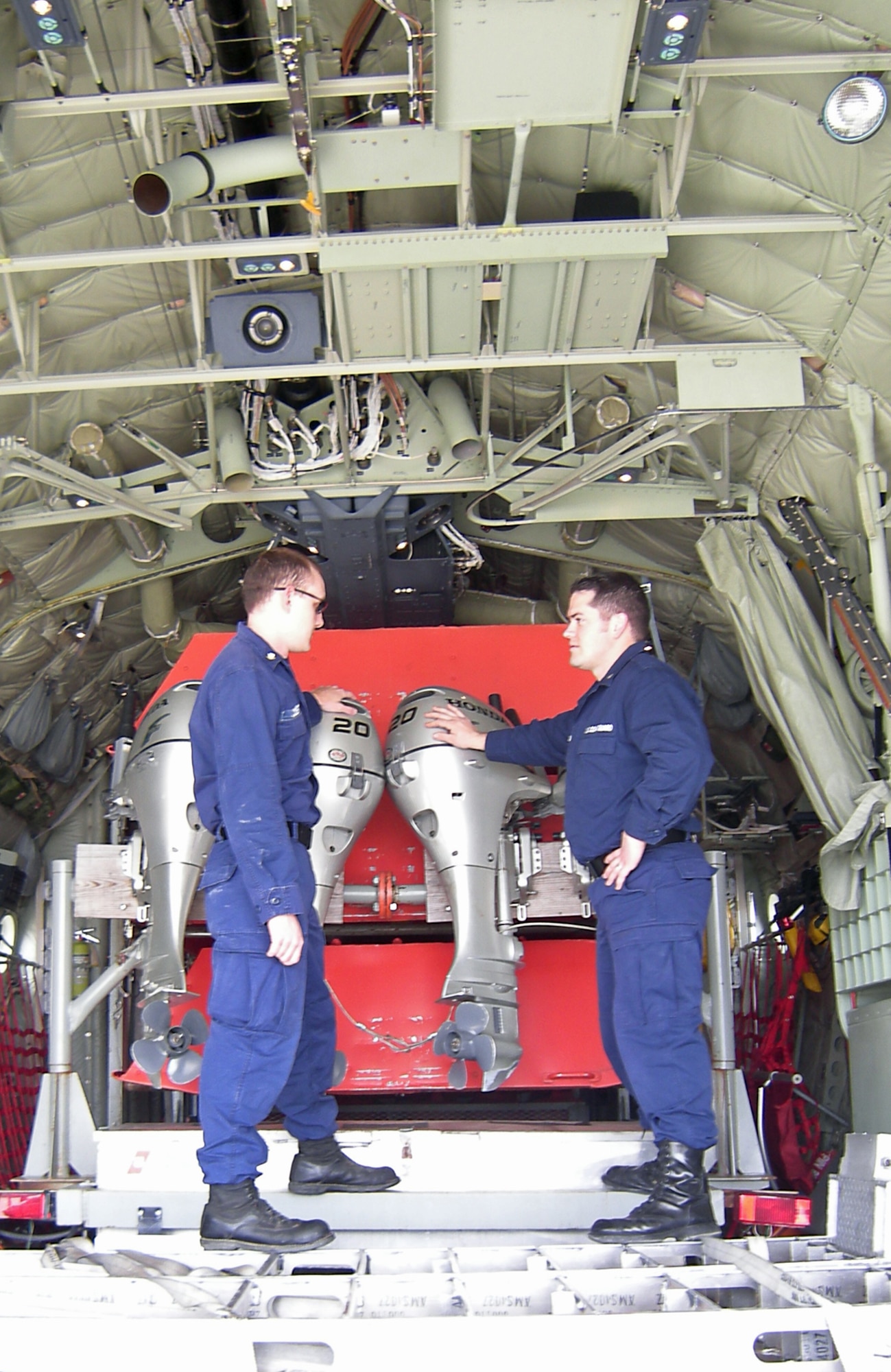 Petty Officers Adler Dobert of Moraine, Ohio (left) and Luke McCabe of Eaton, Ohio inspect equipment loaded aboard a U.S. Coast Guard C-130J Hercules at Wright-Patterson Air Force Base Friday, March 27.  Both are assigned to the U.S. Coast Guard Marine Safety Detachment Cincinnati and are part of an 8-member Disaster Assistance Response Team (DART) bound for Fargo, N.D. to join in flood relief efforts along the Red River there. The aircraft is assigned to Coast Guard Station Elizabeth City, N.C. (U.S. Air Force photo/Derek Kaufman)