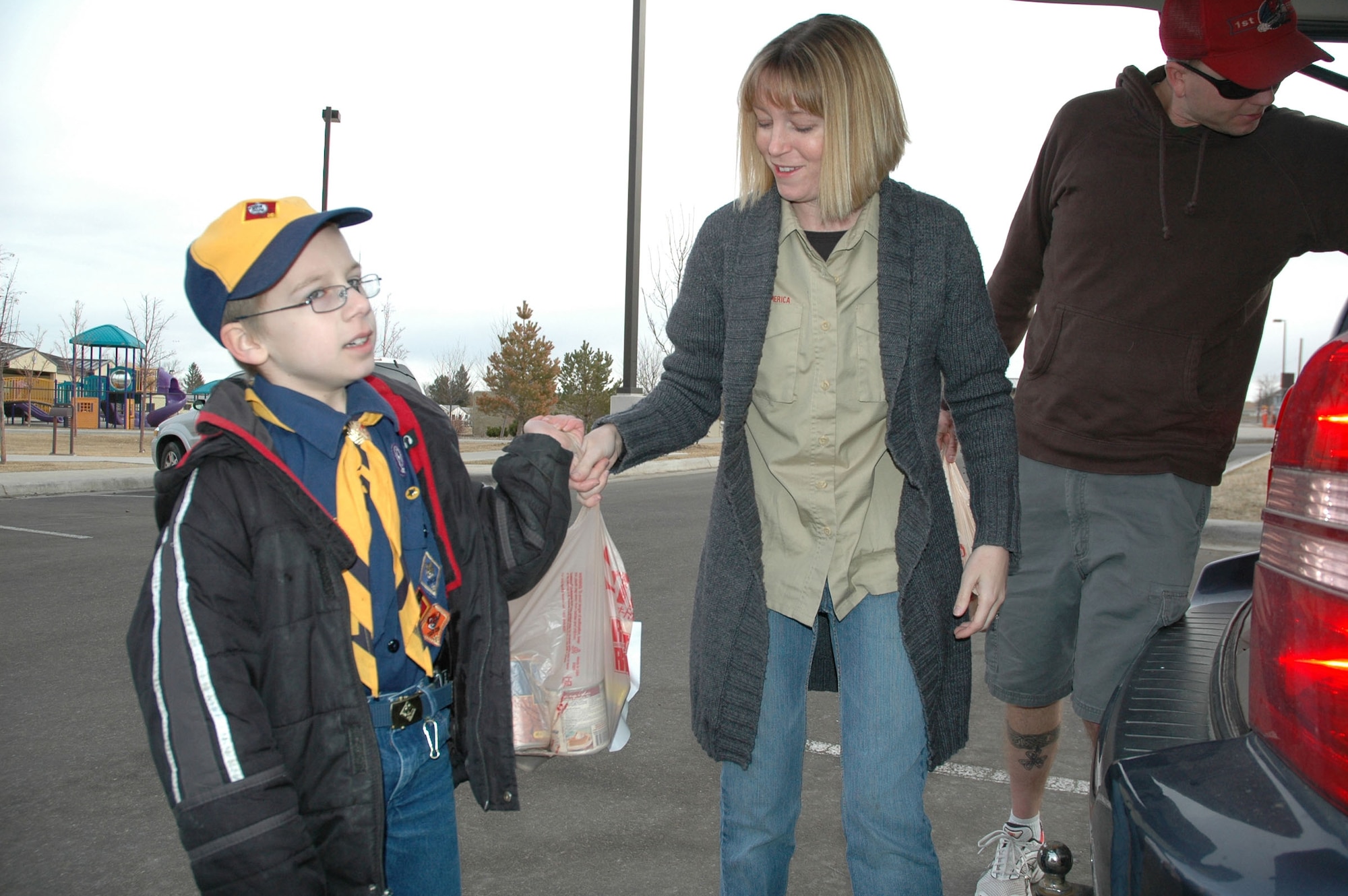Allen, 8, hands a bag of donated food to Brie Riley, March 21. Cub Scout Pack 43 collected 943 pounds of canned food, dry goods and personal hygiene products which were donated to the Great Falls Food Bank, along with donations collected off base by Boy Scout Troop 43 and Malmstrom volunteers. (U.S. Air Force photo/Senior Airman Dillon White)