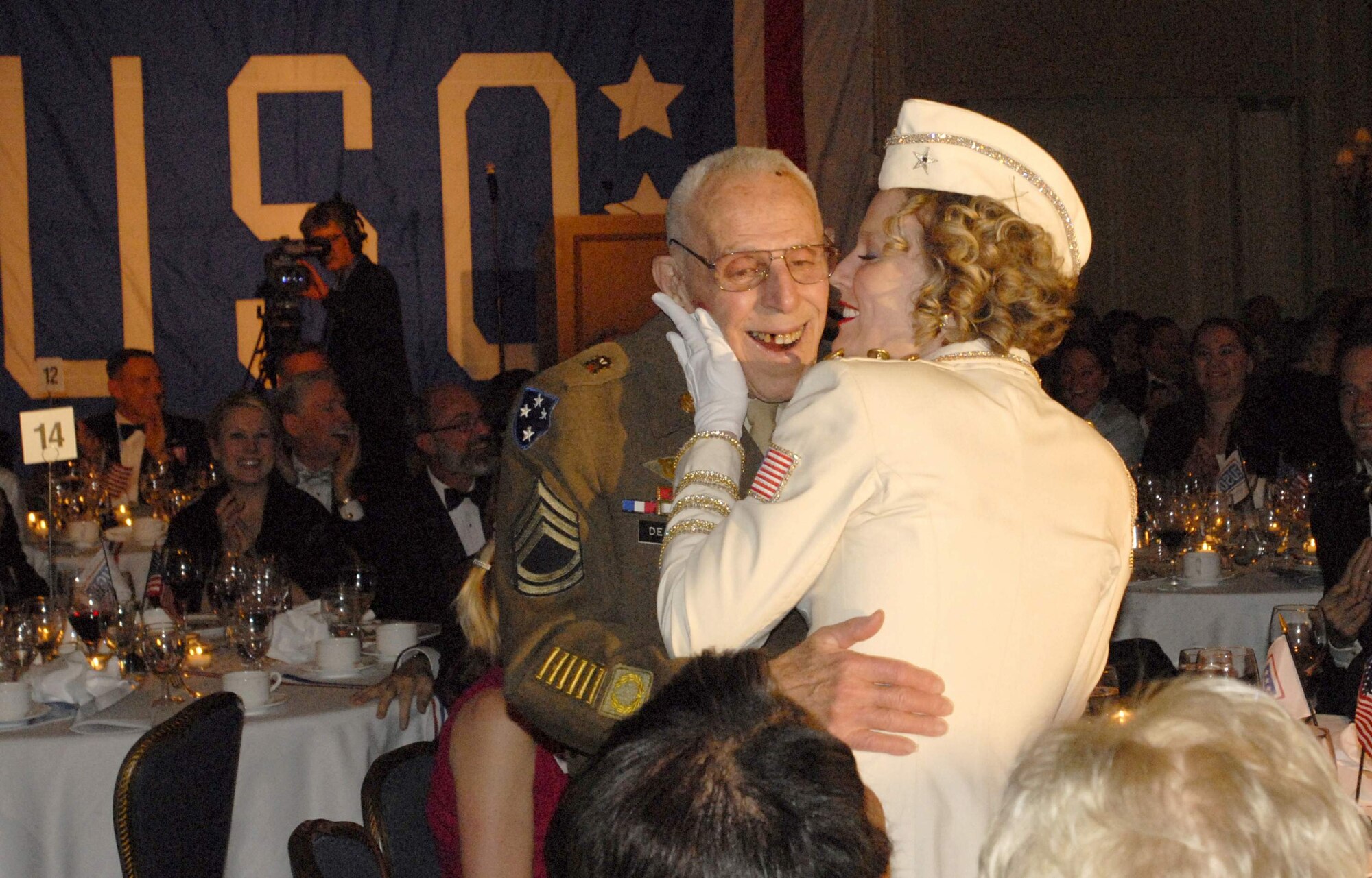 Retired Army Sergeant 1st Class Carlo DePorto gets a smooch from the United Services Organization Amercian Belles member Annie Gane during the USO Annual Award Dinner at the Ritz Carlton March 25 in Washington, D.C. Other volunteers and attendees included model and Fox correspondent Leeann Tweeden, Miss America 2009 Katie Stam, former San Francisco 49er Riki Ellison, and NFL Hall of Famer Anthony Munoz, formerly of the Cincinnati Bengals. (U.S. Air Force photo/Tech. Sgt. Amaani Lyle) 
