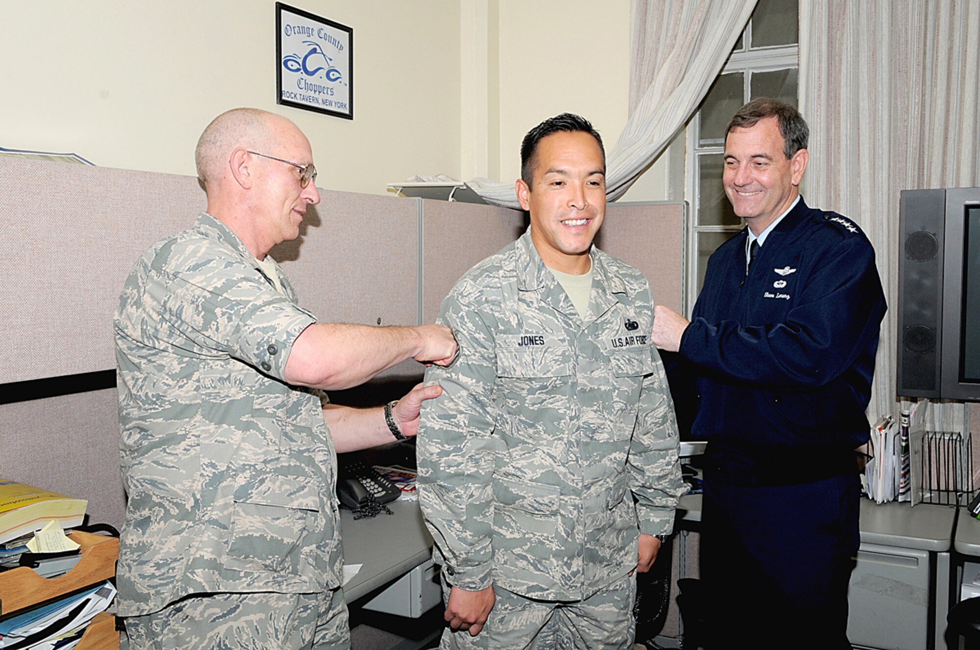 Staff Sgt. Rick Jones braces for a shot in the arm from Gen. Stephen Lorenz (right) and Col. Stan Chase during an impromptu Stripes To Exceptional Performers promotion ceremony March 25 at Randolph Air Force Base, Texas. As a special events NCO and manager of the Air Force NASCAR program, Sergeant Jones was selected for STEP promotion to technical sergeant for outstanding performance in his field. General Lorenz is the Air Education and Training Command commander and Colonel Chase is the vice commander for Air Force Recruiting Service.