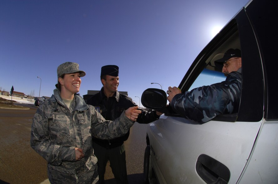 MINOT AIR FORCE BASE, N.D. -- Senior Airman Tashia Weaver, 91st Missile Wing ground safety assistant, and Lt. Col. David Kelley, 91st MW chief of safety, distribute safety reminders to local motorists near the front gate here recently. Airman Weaver was chosen to appear on Rachel Ray's talk show and give her mother a makeover. 2009 was a year that brought progress and a renewed emphasis on safe, secure and reliable nuclear operations. The 91st Missile Wing transitioned to Air Force Global Strike Command with the 5th Bomb Wing scheduled to follow suit in 2010. (U.S. Air Force photo by Tech. Sgt. Lee A. Osberry Jr.)