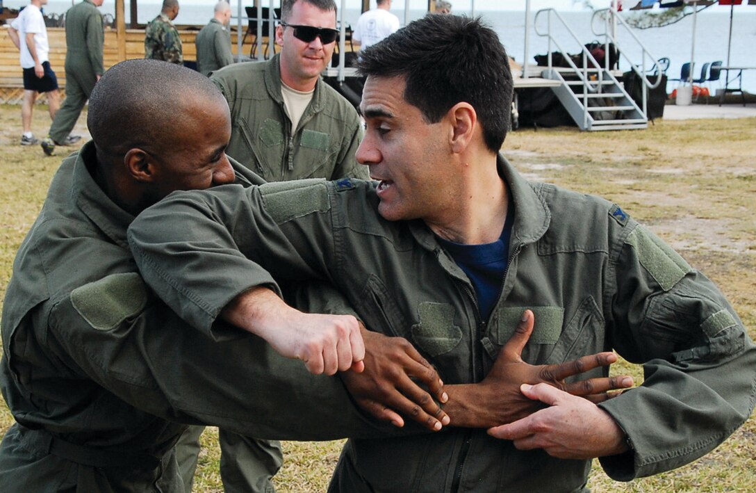 Technical Sgt. Phil Taylor, 201 AS flight attendant, and Col. Marc Sasseville, 113th Wing vice commander, practice hand-to-hand combat training March 14. The 113th Security Forces Squadron Ravens taught the hand-to-hand combat. (U.S. Air Force photo/ Tech. Sgt. Adrianne Wilson)