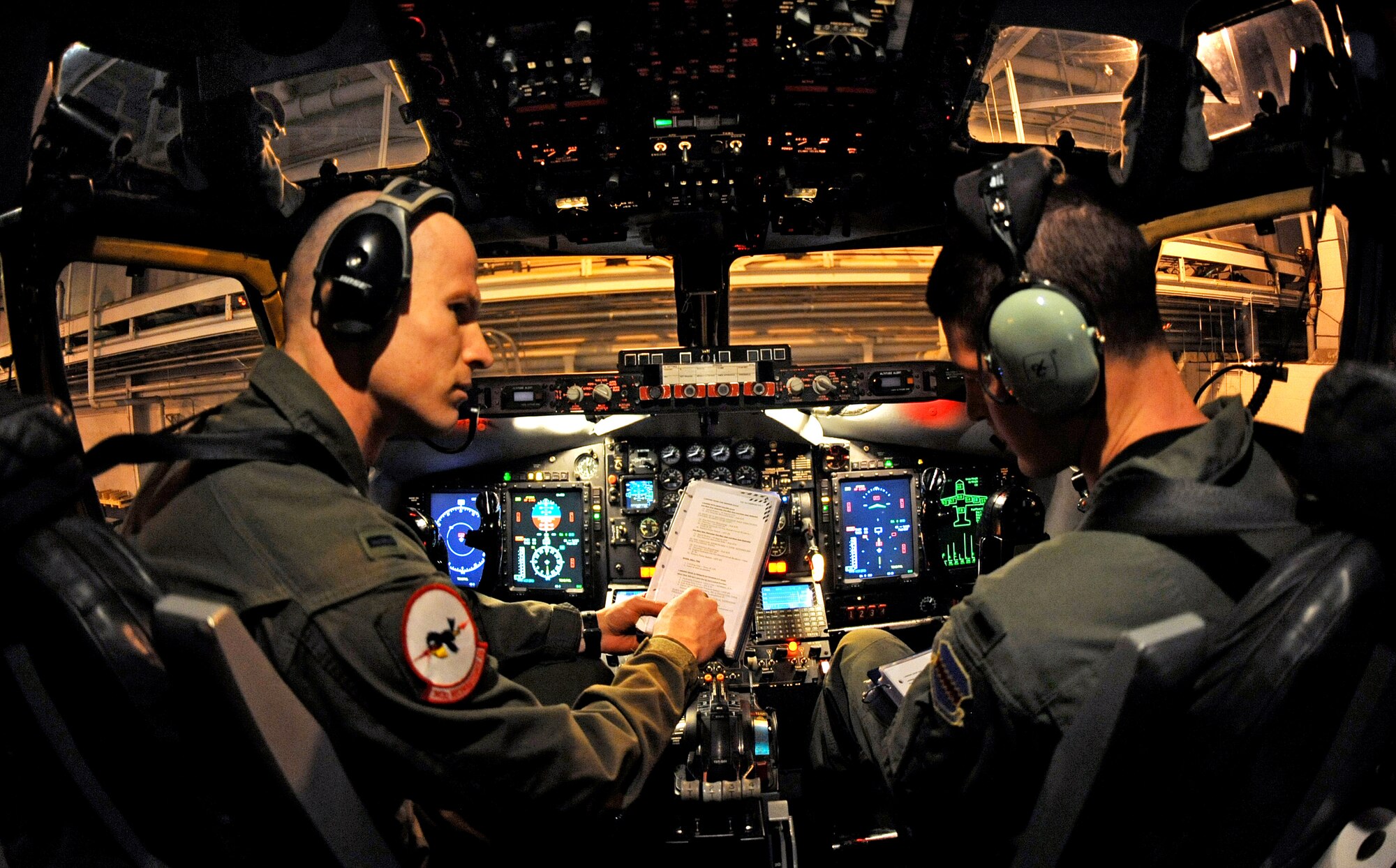 OFFUTT AIR FORCE BASE, Neb.-- 1st Lt. Joshua McCrary, pilot with the 343rd Reconnaissance Squadron, trains 1st Lt. William Schoen, 338th Combat Training Squadron, in the procedures of manually lowering the gear extensions on an RC-135 Rivet Joint Aircraft inside of Dock 2 of the Bennie Davis Maintenance Facility, March, 25.  This training is crucial for aircrew members to master if the landing gear fail to electronically lower.

 U.S. Air Force Photo by Josh Plueger   