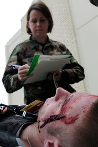 LANGLEY AIR FORCE BASE, Va. -- Capt. Pam Loveland, 1st Medical Group emergency response physician, assesses damage to a wounded patient that suffered a head injury during an All Hazards Response Training Exercise here March 26.  The exercise tested the ability to provide medical care to mass casualties during a simulated chemical attack.  (U.S. Air Force photo/Senior Airman Vernon Young)