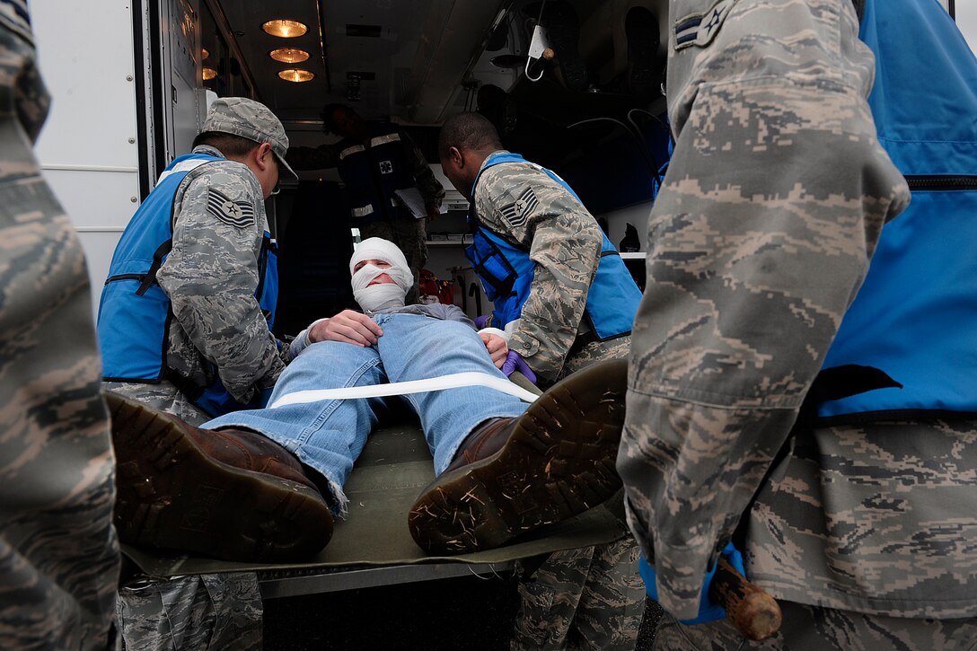 LANGLEY AIR FORCE BASE, Va. -- Airmen from the 1st Medical Group transport a wounded patient that suffered severe burns to his face during an All Hazards Response Training Exercise here on March 26.  The exercise tested the ability to provide medical care to mass casualties during a simulated chemical attack.  (U.S. Air Force photo/Senior Airman Vernon Young)