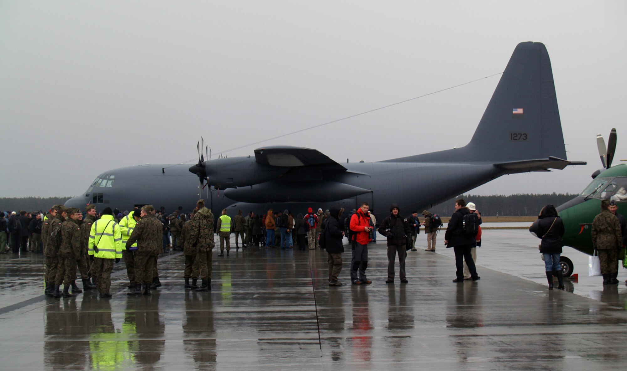Polish visitors and media view the first of five refurbished C-130E Hercules military transport planes and spare parts delivered Tuesday to the Polish Air Force at Powidz Air Base. The entire project, including total refurbishment of five aircraft, support equipment, supplies, training and contracted logistics support, is valued at $120 million. The donation is a result of an American pledge to provide Poland with such a capability, and is fully funded through bilateral military assistance grant money. A Reserve aircrew from Hill Air Force Base, Utah, and an active duty loadmaster from Edwards AFB, Calif., picked the plane up in Waco, Texas, with their Polish counterparts after its refurbishment and flew it across the Atlantic, stopping at Ramstein AB, Germany. It made its final leg to Powidz AB, where it will become part of the 14th Lift Squadron.  (Air Force photo by Capt. Tony Wickman)