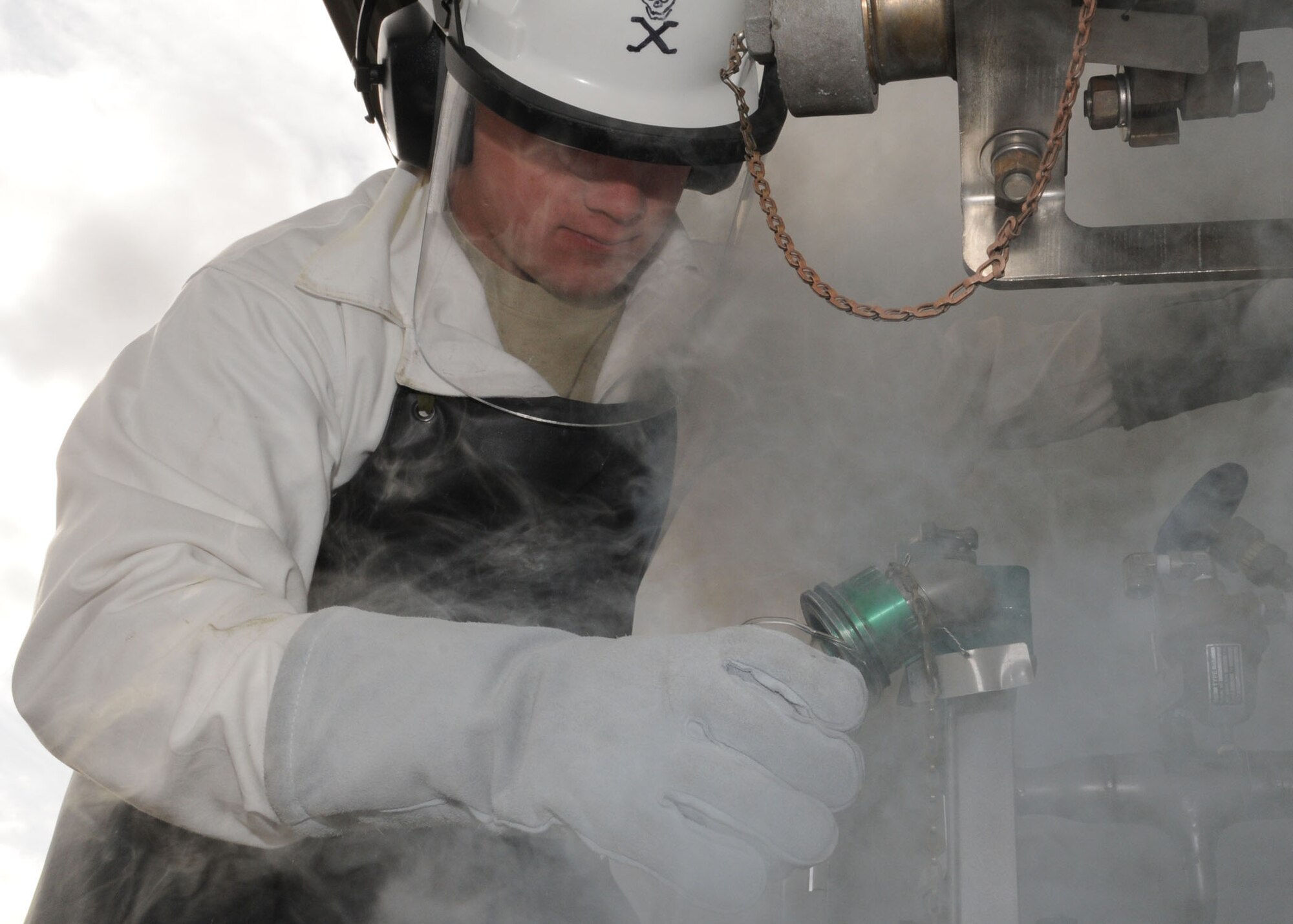 Airman 1st Class Matt Fitch, 100th Logistics Readiness Squadron Petroleum, Oils, and Lubricants apprentice, takes a sample of liquid oxygen “LOX” to test for serviceability March 26, 2009, at RAF Mildenhall, England. The Amarillo, Texas, native wears protective clothing to cover all exposed areas from the -297 degrees Fahrenheit boiling temperature of LOX. Liquid oxygen is pure oxygen in a liquid form and has an expansion ratio of 860:1. This offers aviators and aircrew a longer duration of breathable oxygen without the size and weight of conventional methods. (U.S. Air Force photo by Staff Sgt. Jerry Fleshman)