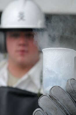 Airman 1st Class Matt Fitch, 100th Logistics Readiness Squadron Petroleum, Oils, and Lubricants apprentice, holds up a frozen beaker of liquid oxygen during a serviceability test March 26, 2009, at RAF Mildenhall, England. Liquid oxygen boils at -297 degrees Fahrenheit with an expansion ratio of 860:1. This offers aviators and aircrew a longer duration of breathable oxygen without the size and weight of conventional methods. (U.S. Air Force photo by Staff Sgt. Jerry Fleshman)