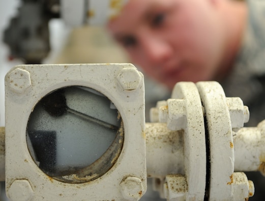 Airman 1st Class Matt Fitch, 100th Logistics Readiness Squadron Petroleum, Oils, and Lubricants apprentice, verifies water being extracted from fuel through a sight glass March 26, 2009, at RAF Mildenhall, England. The Amarillo, Texas, native verifies five 600-gallon fuel filter separator sumps daily to ensure aircraft fuel are completely free of foreign contaminates and water, so that they are safe for aircraft use. (U.S. Air Force photo by Staff Sgt. Jerry Fleshman)
