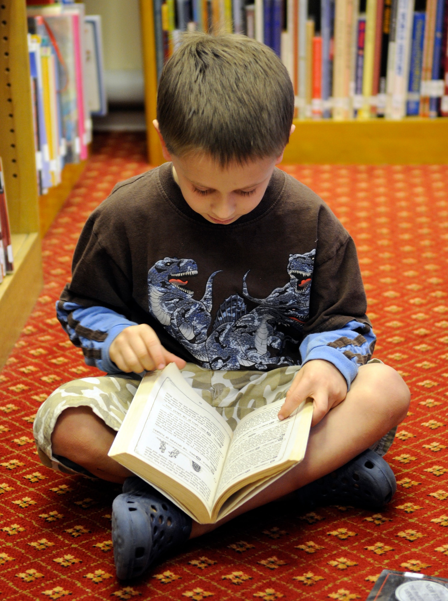 Seven year old Gabriel Ingersoll forgoes finding a chair and reads a book on the floor at the RAF Mildenhall Library, March 25, 2009.  Children’s story time on Wednesdays is one of many programs that brings a lot of children to the Mildenhall Library.  (U.S. Air Force photo by Senior Airman Christopher L. Ingersoll)