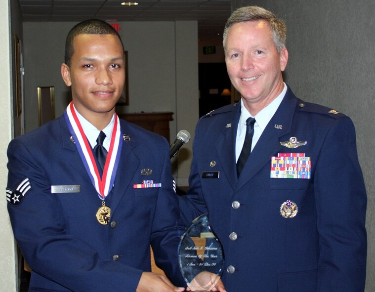 Senior Airman Jair Guevara, 482nd Maintenance Squadron avionics journeyman, is presented a plaque by Brig. Gen. (select) Binger, 482nd Fighter Wing commander, during the Annual Awards Banquet at the Falcon's Nest Club on March 14. Airman Guevara was one of six honorees from the 482nd FW along with annual award recipients from Special Operations Command South, U.S. Coast Guard Maritime Safety and Security Team and Florida Air National Guard. (U.S. Air Force photo/Staff Sgt. Casey Knotts)