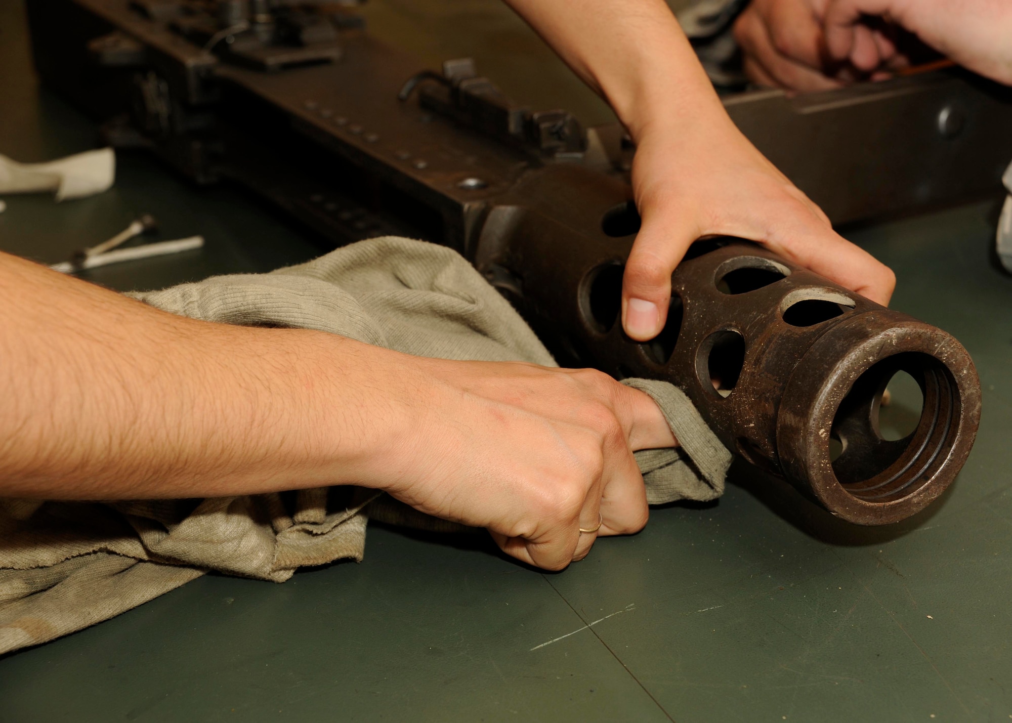 Senior Airman Elizabeth Gonzalez, 447th Expeditionary Security Forces Squadron heavy weapons operator, cleans the .50 caliber machine gun at the armory at Sather Air Base, Iraq March 12, 2009.  Airman Gonzalez provides a show of force for the base, making sure that no unauthorized personnel are allowed on the base.  Airman Gonzalez is one of only a few security forces members qualified on the .50 cal here.  Airman Gonzales is a native of El Paso, Texas and is deployed from the 204th Security Forces Squadron at Biggs Army Airfield, Fort Bliss, and El Paso, Texas Air National Guard. (U.S. Air Force photo by Senior Airman Jacqueline Romero)