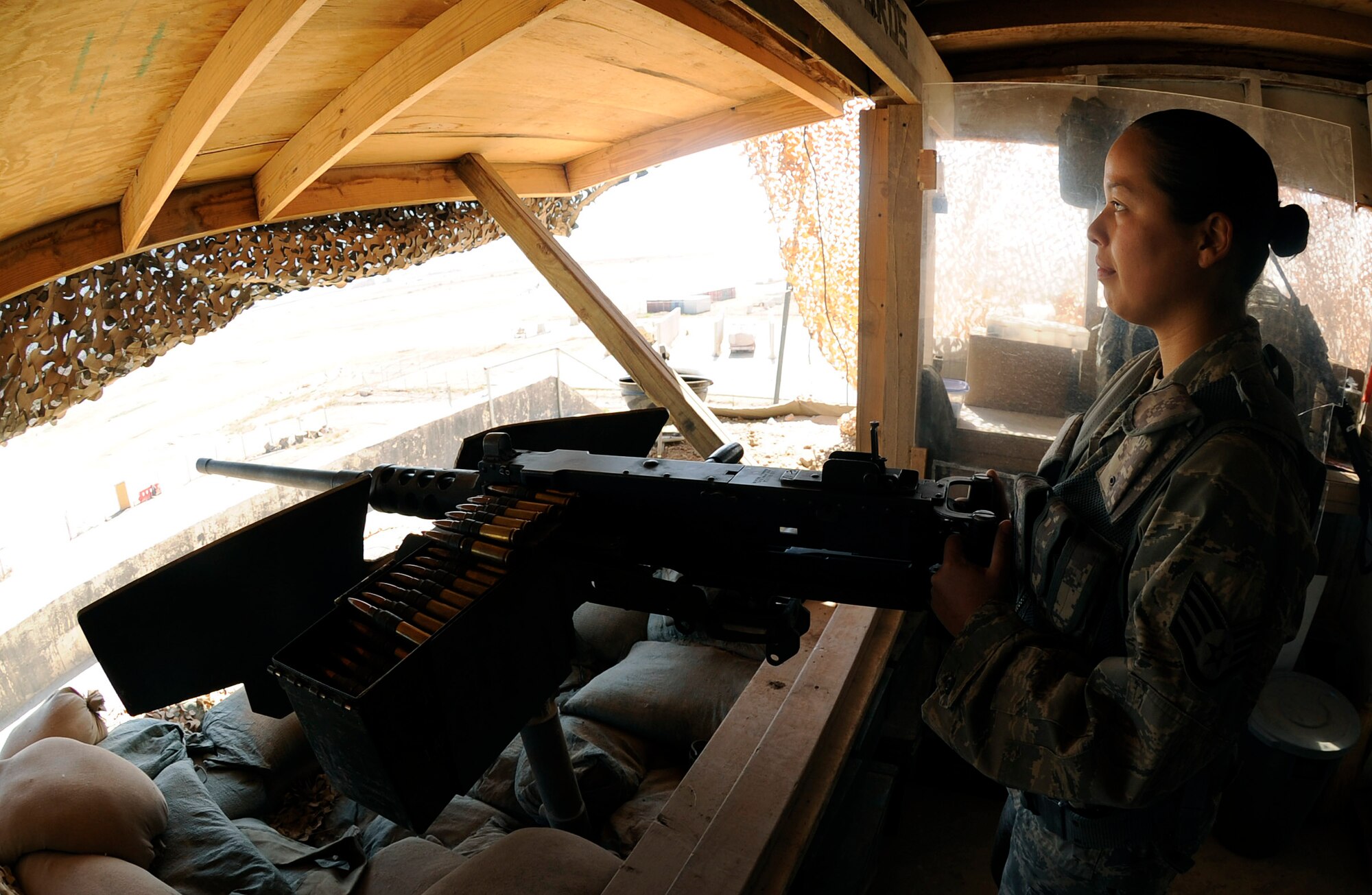 Staff Sgt. Vida Reveles, 447th Expeditionary Security Forces Squadron heavy weapons operator, observes the flight line at Sather Air Base, Iraq while manning a .50 caliber machine gun March 26, 2009.  Sergeant Reveles provides [a]show of force for the base making sure that no unauthorized personnel are allowed on the base.  Sergeant Reveles is one of a few security forces members qualified on the .50 cal here. Sergeant Reveles is a native of Las Cruces, N.M. and is deployed from the 204th Security Forces Squadron at Biggs Army Airfield, Fort Bliss, and El Paso, Texas Air National Guard. (U.S. Air Force photo by Senior Airman Jacqueline Romero)