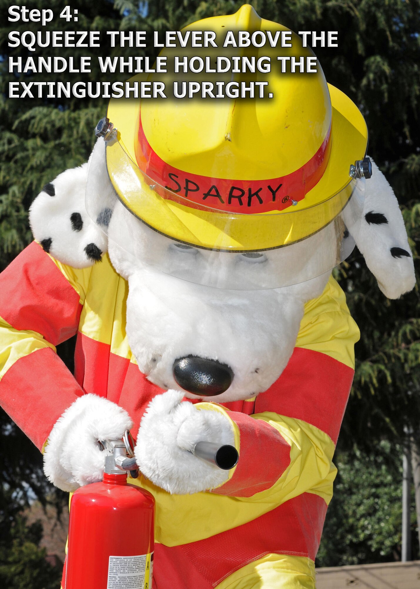 YOKOTA AIR BASE, Japan -- Sparky the Fire Dog demonstrates how to properly engage a fire extinguisher. The 374th Civil Engineer Squadron fire department is promoting spring fire prevention week April 13 through 17. (U.S. Air Force illustration/ Senior Airman Veronica Pierce)