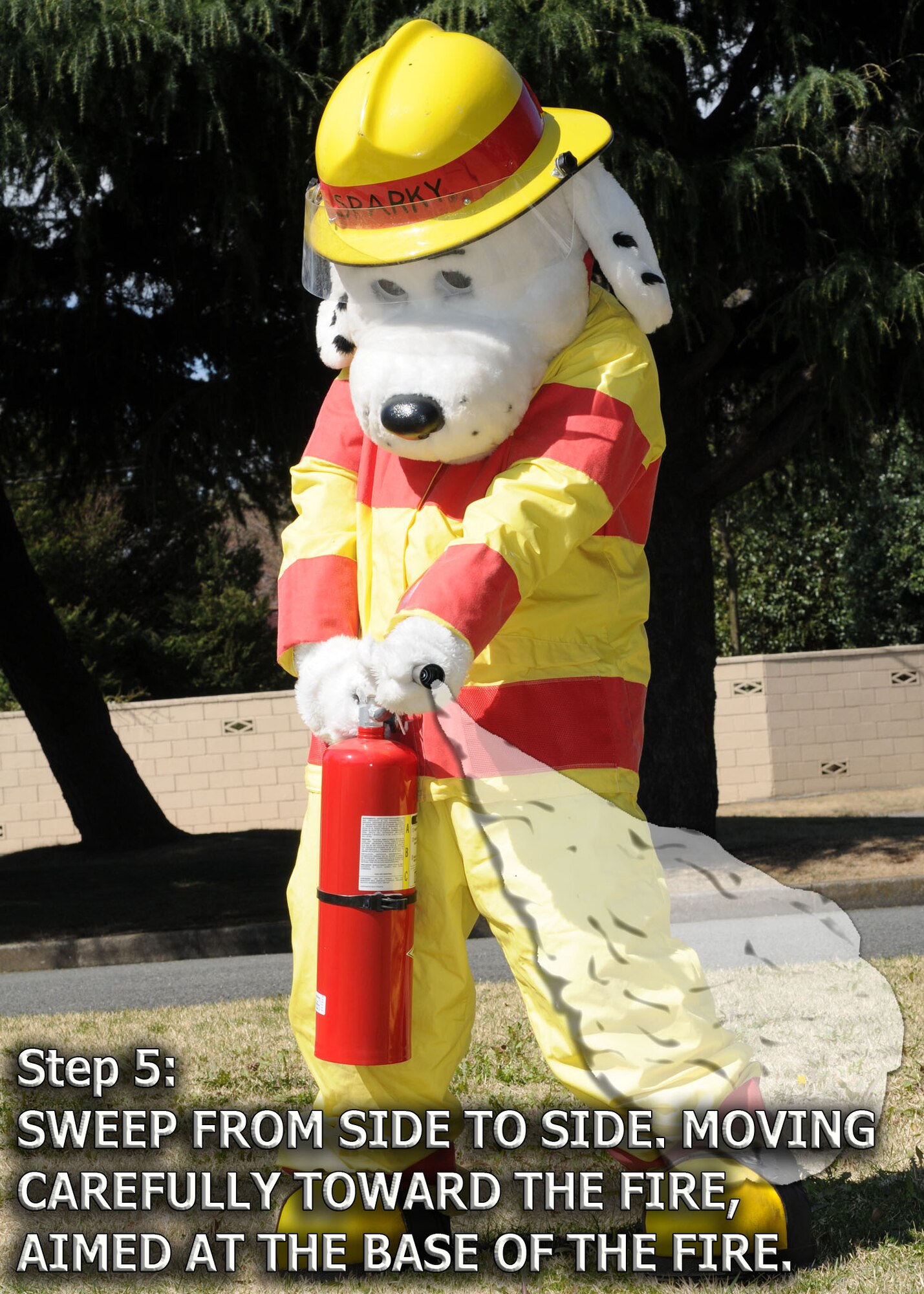 YOKOTA AIR BASE, Japan -- Sparky the Fire Dog demonstrates how to properly engage a fire extinguisher. The 374th Civil Engineer Squadron fire department is promoting spring fire prevention week April 13 through 17. (U.S. Air Force illustration/ Senior Airman Veronica Pierce)
