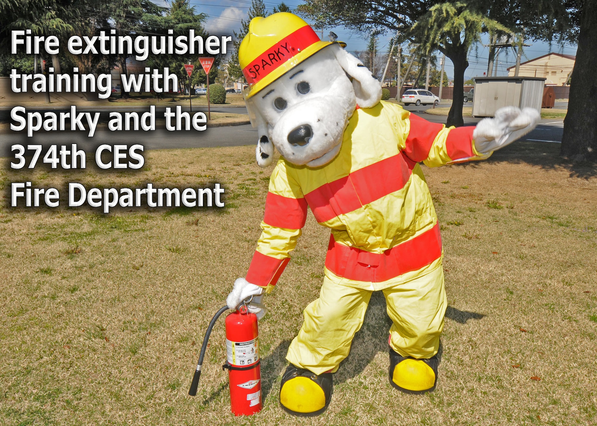 YOKOTA AIR BASE, Japan -- Sparky the Fire Dog demonstrates how to properly engage a fire extinguisher. The 374th Civil Engineer Squadron fire department is promoting spring fire prevention week April 13 through 17. (U.S. Air Force illustration/ Senior Airman Veronica Pierce)