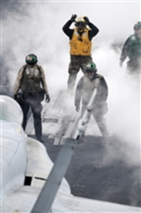 U.S. Navy Airman Daryl Cobb uses hand signals to tell the pilot of an F/A-18C Hornet to move the aircraft forward onto catapult one aboard the aircraft carrier USS Ronald Reagan (CVN 76) underway in the Pacific Ocean on March 20, 2009.  Cobb is under instruction as a flight deck plane handler training for his final qualification to direct personnel and aircraft on the flight deck.  The Ronald Reagan and Carrier Air Wing 14 are conducting a sustainment exercise.  