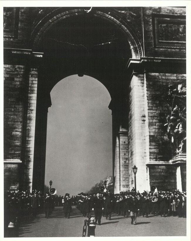 In 1944, General Henry "Hap" Arnold organized an Anglo American Lend-Lease program which called for an exchange of bands between the United States Air Force and the Royal Air Force.  The Army Air Forces Band's left Bolling Field on December 5, 1944 and returned on April 5, 1945.  This photo was taken on March 15, 1945 at the Arc de Triomphe in Paris, France.  According to Master Sgt. (USAF, Ret.) Ivan Genuchi's detailed scrapbook from that tour, this was a posed photo, i.e. no parade and no concert (much to the disappointment of the civilian population).  After the Band returned from this photo op, several were treated to a performance that evening by the Glenn Miller Army Air Forces Band in the hotel dining room in Paris and again during the Miller Band's 10 p.m. recording session.