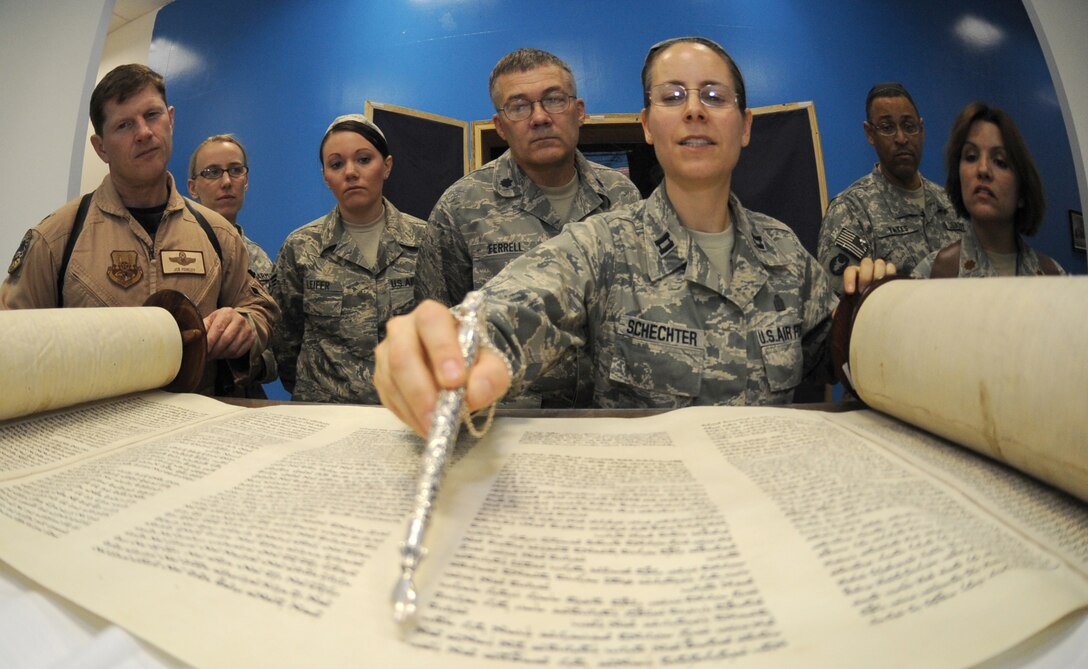 JOINT BASE BALAD, Iraq -- Chaplain (Capt.) Sarah Schechter, 332nd Air Expeditionary Wing rabbi, describes the newly arrived Jewish Torah following a Torah dedication ceremony at Gilbert Memorial Chapel here March 21. A Torah is a big parchment leather scroll on which the Five Books of Moses are handwritten in Hebrew. For thousands of years, this is how Jews have maintained their law, teachings, religion and society. (U.S. Air Force photo/Senior Airman Elizabeth Rissmiller)