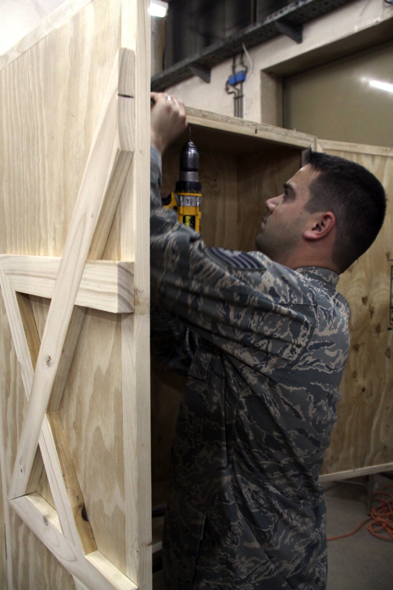 JOINT BASE BALAD, Iraq -- Staff Sgt. Christopher Dudas, 332nd Expeditionary Civil Engineer Squadron structural craftsman, carefully drills tiny holes into the newly crafted ark that he volunteered to make for Gilbert Memorial Chapel. The ark will house a Torah, which is a big parchment leather scroll on which the Five Books of Moses are handwritten in Hebrew and the foundation for Jewish law, teachings, religion and society. Dudas is deployed from Hickam Air Force Base, Hawaii; his hometown is Lyndonville, Vt. (U.S. Air Force photo/Tech. Sgt. Lionel Castellano)  